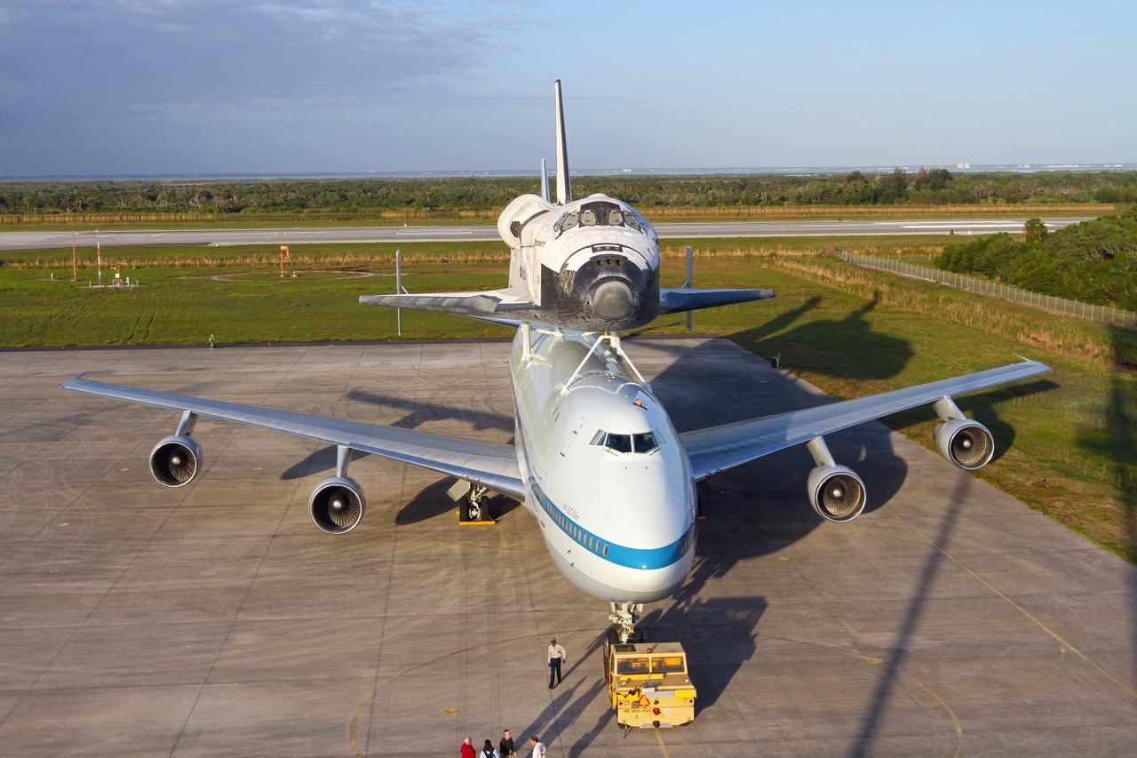CAPE CANAVERAL, Fla. – The Shuttle Carrier Aircraft carrying space shuttle Discovery is on the ramp of the Shuttle Landing Facility at NASA’s Kennedy Space Center in Florida. Earlier, the duo backed out of the mate-demate device. Known as the MDD, the device is a large gantry-like steel structure used to hoist a shuttle off the ground and position it onto the back of the aircraft, or SCA. The SCA is a Boeing 747 jet that was originally manufactured for commercial use and modified by NASA to transport the shuttles between destinations on Earth. This SCA, designated NASA 905, is assigned to the remaining ferry missions, delivering the shuttles to their permanent public display sites.       NASA 905 is scheduled to ferry Discovery to the Washington Dulles International Airport in Virginia on April 17, after which the shuttle will be placed on display in the Smithsonian's National Air and Space Museum Steven F. Udvar-Hazy Center. For more information on the SCA, visit http://www.nasa.gov/centers/dryden/news/FactSheets/FS-013-DFRC.html. For more information on shuttle transition and retirement activities, visit http://www.nasa.gov/transition. Photo credit: NASA/Kim Shiflett