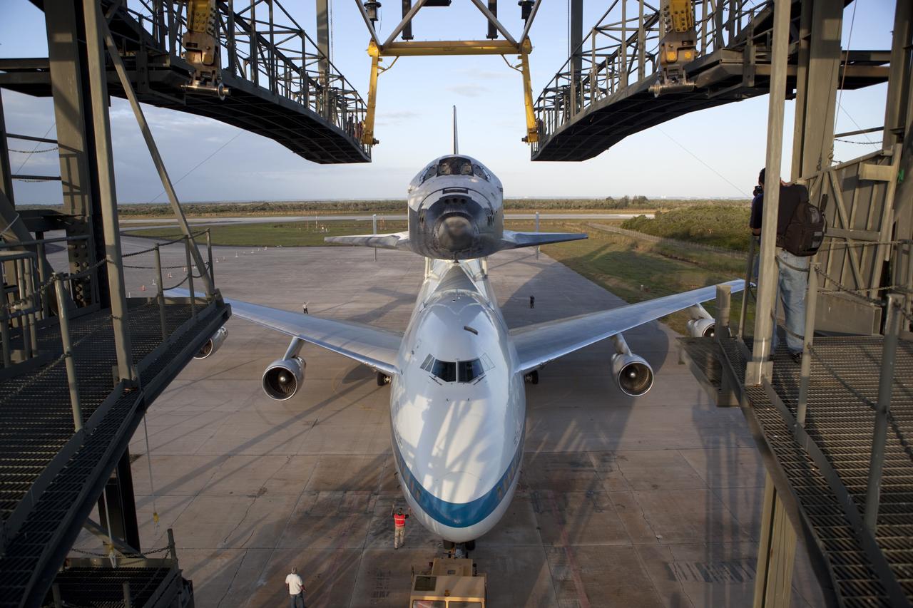 CAPE CANAVERAL, Fla. – At NASA Kennedy Space Center’s Shuttle Landing Facility in Florida, the Shuttle Carrier Aircraft, or SCA, with space shuttle Discovery attached atop, backs away from the mate/demate device. Known as the MDD, the devise is a large gantry-like steel structure used to hoist a shuttle off the ground and position it onto the back of the SCA. The SCA is a Boeing 747 jet that was originally manufactured for commercial use and modified by NASA to transport the shuttles between destinations on Earth. This SCA, designated NASA 905, is assigned to the remaining ferry missions, delivering the shuttles to their permanent public display sites. NASA 905 is scheduled to ferry Discovery to the Washington Dulles International Airport in Virginia on April 17, after which the shuttle will be placed on display in the Smithsonian’s National Air and Space Museum, Steven F. Udvar-Hazy Center in Chantilly, Va. For more information on the SCA, visit http://www.nasa.gov/centers/dryden/news/FactSheets/FS-013-DFRC.html. For more information on shuttle transition and retirement activities, visit http://www.nasa.gov/transition. Photo credit: NASA/Dimitri Gerondidakis