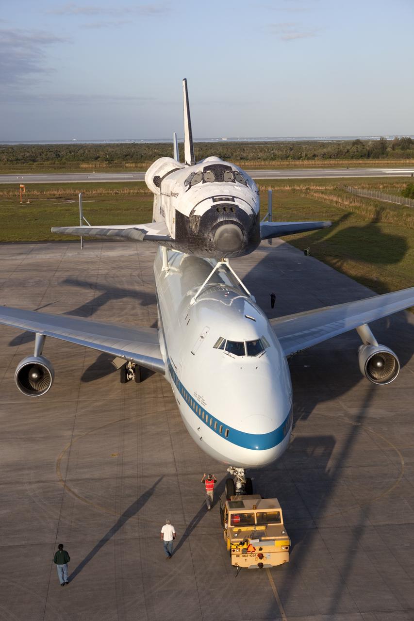 CAPE CANAVERAL, Fla. – At NASA Kennedy Space Center’s Shuttle Landing Facility in Florida, the Shuttle Carrier Aircraft, or SCA, with space shuttle Discovery attached atop, is backed away from the mate/demate device. Known as the MDD, the devise is a large gantry-like steel structure used to hoist a shuttle off the ground and position it onto the back of the SCA. The SCA is a Boeing 747 jet that was originally manufactured for commercial use and modified by NASA to transport the shuttles between destinations on Earth. This SCA, designated NASA 905, is assigned to the remaining ferry missions, delivering the shuttles to their permanent public display sites. NASA 905 is scheduled to ferry Discovery to the Washington Dulles International Airport in Virginia on April 17, after which the shuttle will be placed on display in the Smithsonian’s National Air and Space Museum, Steven F. Udvar-Hazy Center in Chantilly, Va. For more information on the SCA, visit http://www.nasa.gov/centers/dryden/news/FactSheets/FS-013-DFRC.html. For more information on shuttle transition and retirement activities, visit http://www.nasa.gov/transition. Photo credit: NASA/Dimitri Gerondidakis