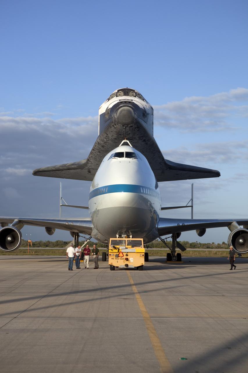 CAPE CANAVERAL, Fla. – At NASA Kennedy Space Center’s Shuttle Landing Facility in Florida, the Shuttle Carrier Aircraft, or SCA, with space shuttle Discovery attached atop, sits on the tarmac after being backed away from the mate/demate device. Known as the MDD, the devise is a large gantry-like steel structure used to hoist a shuttle off the ground and position it onto the back of the SCA. The SCA is a Boeing 747 jet that was originally manufactured for commercial use and modified by NASA to transport the shuttles between destinations on Earth. This SCA, designated NASA 905, is assigned to the remaining ferry missions, delivering the shuttles to their permanent public display sites. NASA 905 is scheduled to ferry Discovery to the Washington Dulles International Airport in Virginia on April 17, after which the shuttle will be placed on display in the Smithsonian’s National Air and Space Museum, Steven F. Udvar-Hazy Center in Chantilly, Va. For more information on the SCA, visit http://www.nasa.gov/centers/dryden/news/FactSheets/FS-013-DFRC.html. For more information on shuttle transition and retirement activities, visit http://www.nasa.gov/transition. Photo credit: NASA/Dimitri Gerondidakis