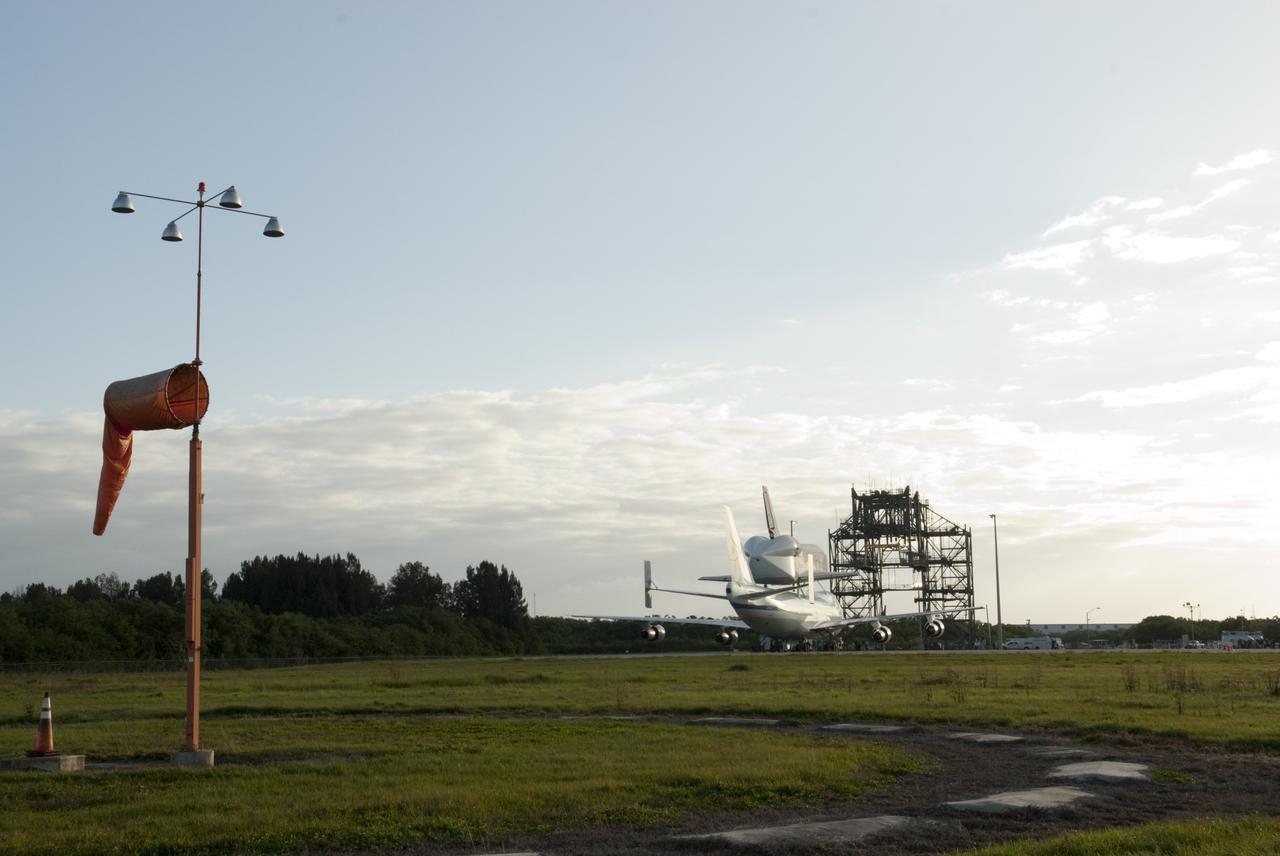 CAPE CANAVERAL, Fla. – At the Shuttle Landing Facility at NASA’s Kennedy Space Center in Florida, no weather constraints to the planned flight plan are detected for departure tomorrow morning of the Shuttle Carrier Aircraft with space shuttle Discovery secured to its back. In the distance, at right, is the mate/demate device used to lift Discovery onto the aircraft.    The device, also known as the MDD, is a large gantry-like steel structure used to hoist a shuttle off the ground and position it onto the back of the aircraft, or SCA. The SCA is a Boeing 747 jet, originally manufactured for commercial use, which was modified by NASA to transport the shuttles between destinations on Earth. The SCA designated NASA 905 is assigned to the remaining ferry missions, delivering the shuttles to their permanent public display sites.  NASA 905 is scheduled to ferry Discovery to the Washington Dulles International Airport in Virginia on April 17, after which the shuttle will be placed on display in the Smithsonian's National Air and Space Museum Steven F. Udvar-Hazy Center. For more information on the SCA, visit http://www.nasa.gov/centers/dryden/news/FactSheets/FS-013-DFRC.html. For more information on shuttle transition and retirement activities, visit http://www.nasa.gov/transition. Photo credit: NASA/Tim Jacobs  The aircraft, also known as an SCA, is a Boeing 747 jet, originally manufactured for commercial use, which was modified by NASA to transport the shuttles between destinations on Earth. The SCA designated NASA 905 is assigned to the remaining ferry missions, delivering the shuttles to their permanent public display sites.  NASA 905 is scheduled to ferry Discovery to the Washington Dulles International Airport in Virginia on April 17, after which the shuttle will be placed on display in the Smithsonian's National Air and Space Museum Steven F. Udvar-Hazy Center. For more information on the SCA, visit http://www.nasa.gov/centers/dryden/news/FactSheets/FS-013-DFRC.html. For more information on shuttle transition and retirement activities, visit http://www.nasa.gov/transition. Photo credit: NASA/Tim Jacobs