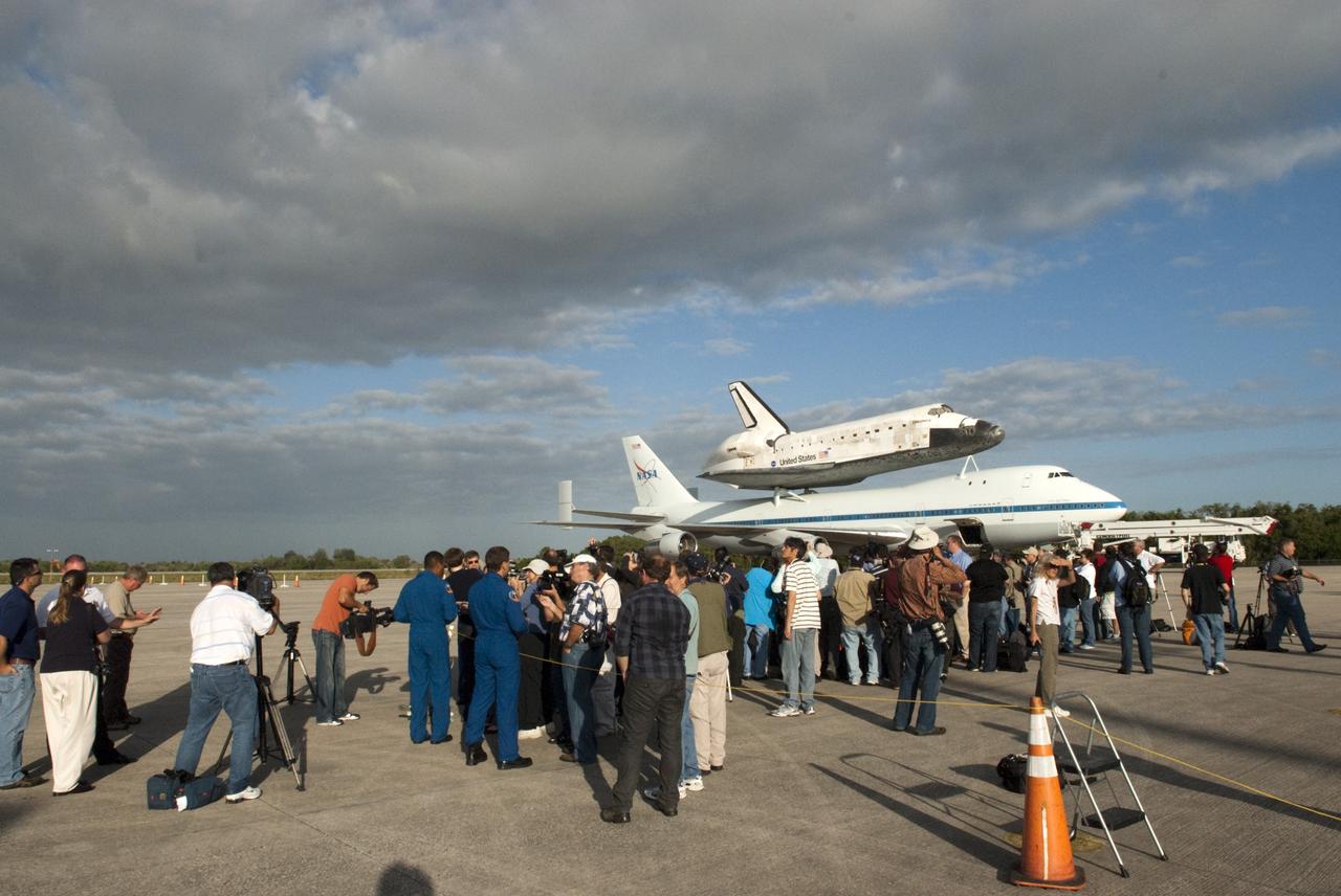 CAPE CANAVERAL, Fla. – At the Shuttle Landing Facility at NASA’s Kennedy Space Center in Florida, media representatives interview members of the last astronaut crew to fly aboard space shuttle Discovery, in the background, which is scheduled to depart from Kennedy for the final time tomorrow morning aboard a Shuttle Carrier Aircraft. Members of the crew of Discovery’s last mission, STS-133, were Commander Steve Lindsey, Pilot Eric Boe, and Mission Specialists Nicole Stott, Michael Barratt, Alvin Drew and Steve Bowen.    Also known as an SCA, the aircraft is a Boeing 747 jet, originally manufactured for commercial use, which was modified by NASA to transport the shuttles between destinations on Earth. The SCA designated NASA 905 is assigned to the remaining ferry missions, delivering the shuttles to their permanent public display sites.  NASA 905 is scheduled to ferry Discovery to the Washington Dulles International Airport in Virginia on April 17, after which the shuttle will be placed on display in the Smithsonian's National Air and Space Museum Steven F. Udvar-Hazy Center. For more information on the SCA, visit http://www.nasa.gov/centers/dryden/news/FactSheets/FS-013-DFRC.html. For more information on shuttle transition and retirement activities, visit http://www.nasa.gov/transition. Photo credit: NASA/Tim Jacobs