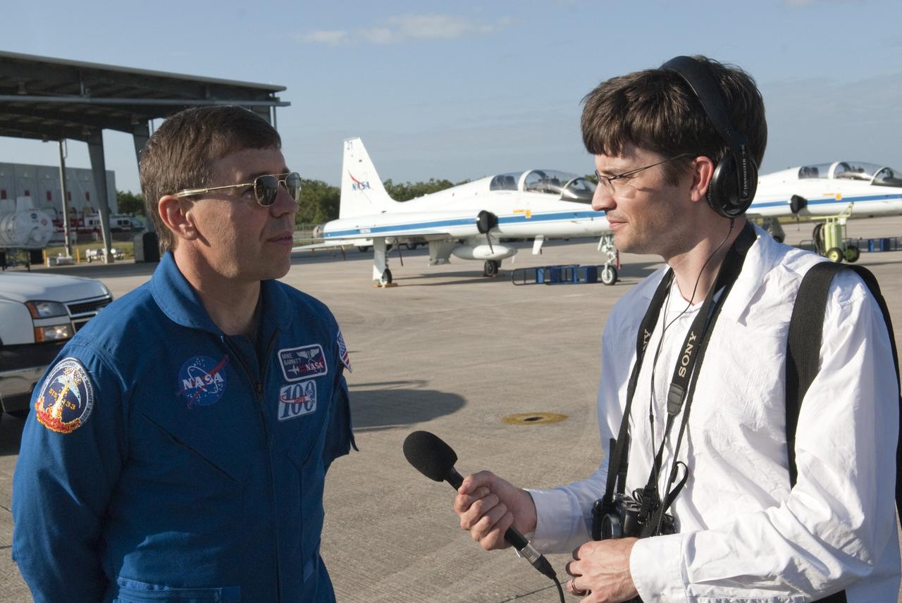CAPE CANAVERAL, Fla. – At the Shuttle Landing Facility at NASA’s Kennedy Space Center in Florida, STS-133 Mission Specialist Michael Barratt talks to a representative of the media with NASA T-38 jets in the background.  Barratt was a member of the crew to fly on Discovery’s final mission in February and March 2011.  Other members of the STS-133 crew were Commander Steve Lindsey, Pilot Eric Boe and Mission Specialists Nicole Stott, Michael Barratt, Alvin Drew and Steve Bowen. Discovery is scheduled to depart from Kennedy for the final time tomorrow morning on the back of a Shuttle Carrier Aircraft.    Also known as an SCA, the aircraft is a Boeing 747 jet, originally manufactured for commercial use, which was modified by NASA to transport the shuttles between destinations on Earth. The SCA designated NASA 905 is assigned to the remaining ferry missions, delivering the shuttles to their permanent public display sites.  NASA 905 is scheduled to ferry Discovery to the Washington Dulles International Airport in Virginia on April 17, after which the shuttle will be placed on display in the Smithsonian's National Air and Space Museum Steven F. Udvar-Hazy Center. For more information on the SCA, visit http://www.nasa.gov/centers/dryden/news/FactSheets/FS-013-DFRC.html. For more information on shuttle transition and retirement activities, visit http://www.nasa.gov/transition. Photo credit: NASA/Tim Jacobs