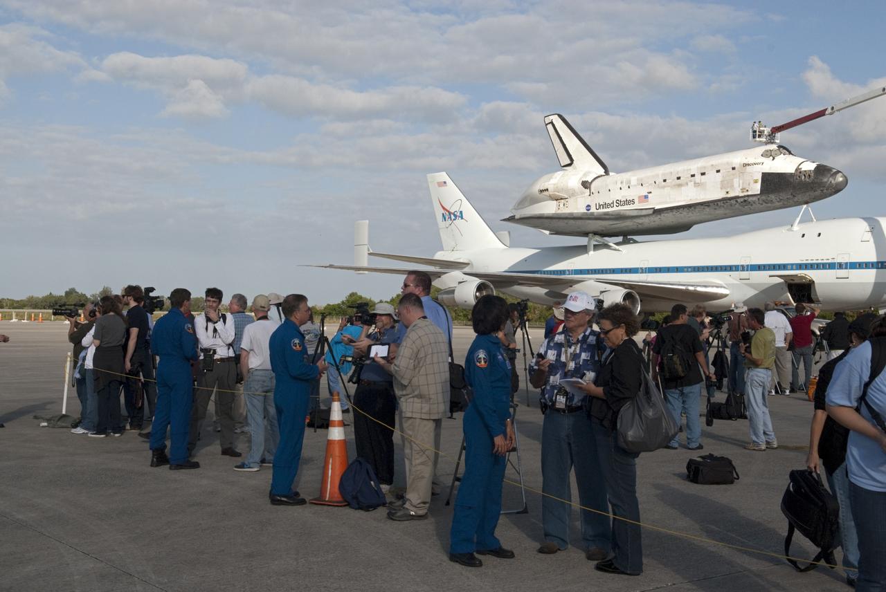 CAPE CANAVERAL, Fla. – At the Shuttle Landing Facility at NASA’s Kennedy Space Center in Florida, media representatives interview members of the last astronaut crew to fly aboard space shuttle Discovery, in the background, which is scheduled to depart from Kennedy for the final time tomorrow morning aboard a Shuttle Carrier Aircraft. Members of the crew of Discovery’s last mission, STS-133, were Commander Steve Lindsey, Pilot Eric Boe, and Mission Specialists Nicole Stott, Michael Barratt, Alvin Drew and Steve Bowen.      Also known as an SCA, the aircraft is a Boeing 747 jet, originally manufactured for commercial use, which was modified by NASA to transport the shuttles between destinations on Earth. The SCA designated NASA 905 is assigned to the remaining ferry missions, delivering the shuttles to their permanent public display sites.  NASA 905 is scheduled to ferry Discovery to the Washington Dulles International Airport in Virginia on April 17, after which the shuttle will be placed on display in the Smithsonian's National Air and Space Museum Steven F. Udvar-Hazy Center. For more information on the SCA, visit http://www.nasa.gov/centers/dryden/news/FactSheets/FS-013-DFRC.html. For more information on shuttle transition and retirement activities, visit http://www.nasa.gov/transition. Photo credit: NASA/Tim Jacobs
