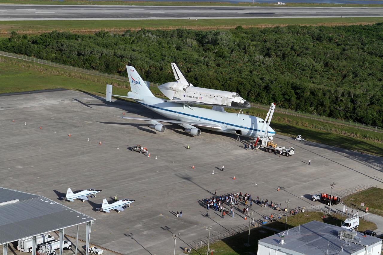 CAPE CANAVERAL, Fla. – This is an aerial view of space shuttle Discovery bolted to the top of a Shuttle Carrier Aircraft SCA on the ramp of the Shuttle Landing Facility SLF at NASA’s Kennedy Space Center in Florida. Also on the ramp is a pair of T-38 training jets. Discovery's last crew members are expected to be at the SLF, along with Kennedy employees and guests, as the center says goodbye to the agency's most-flown shuttle on April 17. The SCA, designated NASA 905, will ferry Discovery to the Washington Dulles International Airport in Virginia, after which the shuttle will be moved for public display in the Smithsonian's National Air and Space Museum Steven F. Udvar-Hazy Center on April 19.                For more information on the SCA, visit http://www.nasa.gov/centers/dryden/news/FactSheets/FS-013-DFRC.html. For more information on shuttle transition and retirement activities, visit http://www.nasa.gov/transition. Photo credit: NASA/Kim Shiflett