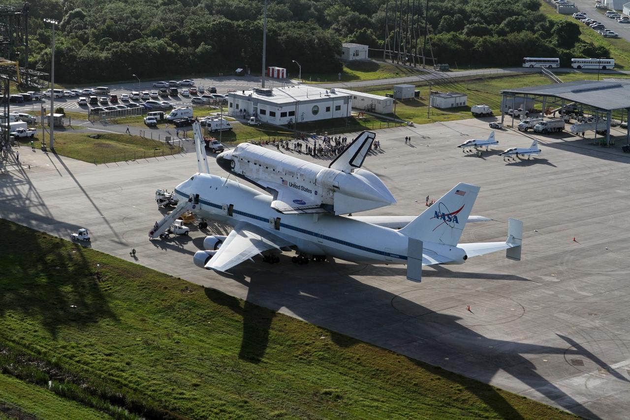 CAPE CANAVERAL, Fla. – This is an aerial view of space shuttle Discovery bolted to the top of a Shuttle Carrier Aircraft SCA on the ramp of the Shuttle Landing Facility SLF at NASA’s Kennedy Space Center in Florida. Also on the ramp is a pair of T-38 training jets. Discovery's last crew members are expected to be at the SLF, along with Kennedy employees and guests, as the center says goodbye to the agency's most-flown shuttle on April 17. The SCA, designated NASA 905, will ferry Discovery to the Washington Dulles International Airport in Virginia, after which the shuttle will be moved for public display in the Smithsonian's National Air and Space Museum Steven F. Udvar-Hazy Center on April 19.        For more information on the SCA, visit http://www.nasa.gov/centers/dryden/news/FactSheets/FS-013-DFRC.html. For more information on shuttle transition and retirement activities, visit http://www.nasa.gov/transition. Photo credit: NASA/Kim Shiflett