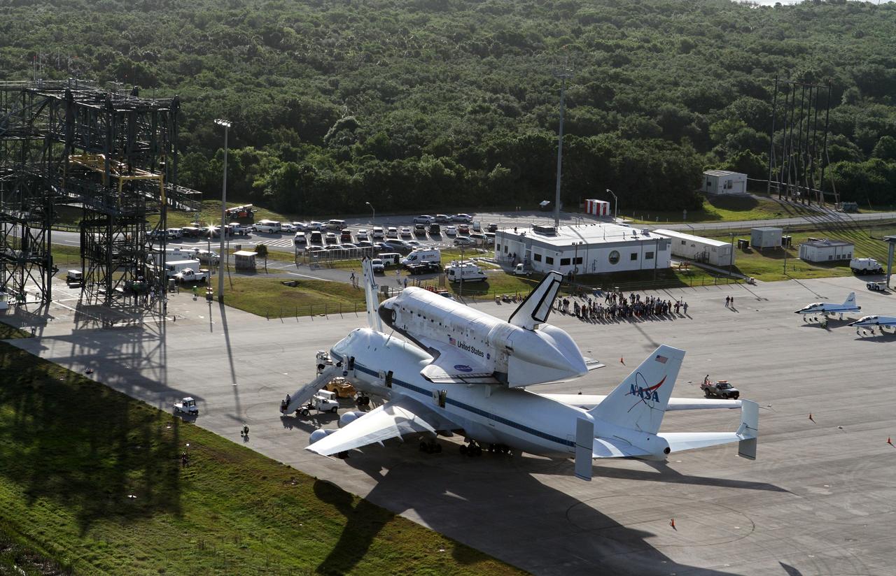 CAPE CANAVERAL, Fla. – This is an aerial view of space shuttle Discovery bolted to the top of a Shuttle Carrier Aircraft SCA on the ramp of the Shuttle Landing Facility SLF at NASA’s Kennedy Space Center in Florida. Also on the ramp is a pair of T-38 training jets. Discovery's last crew members are expected to be at the SLF, along with Kennedy employees and guests, as the center says goodbye to the agency's most-flown shuttle on April 17. The mate/demate device, known as the MDD, is in view and is where transition and retirement teams prepared the duo for the ferry flight. The SCA, designated NASA 905, will ferry Discovery to the Washington Dulles International Airport in Virginia, after which the shuttle will be moved for public display in the Smithsonian's National Air and Space Museum Steven F. Udvar-Hazy Center on April 19. For more information on the SCA, visit http://www.nasa.gov/centers/dryden/news/FactSheets/FS-013-DFRC.html. For more information on shuttle transition and retirement activities, visit http://www.nasa.gov/transition. Photo credit: NASA/Kim Shiflett