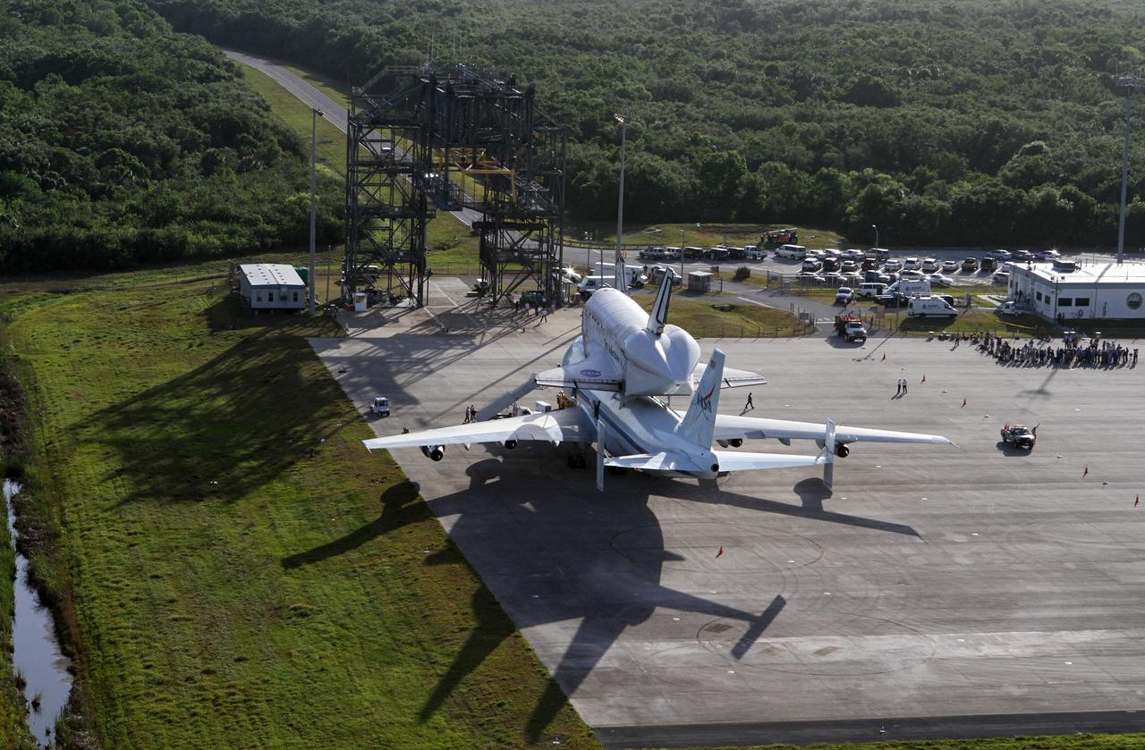 CAPE CANAVERAL, Fla. – This is an aerial view of space shuttle Discovery bolted to the top of a Shuttle Carrier Aircraft SCA on the ramp of the Shuttle Landing Facility SLF at NASA’s Kennedy Space Center in Florida. The mate/demate device, known as the MDD, also is in view and is where transition and retirement teams prepared the duo for the ferry flight. Discovery's last crew members are expected to be at the SLF, along with Kennedy employees and guests, as the center says goodbye to the agency's most-flown shuttle on April 17. The SCA, designated NASA 905, will ferry Discovery to the Washington Dulles International Airport in Virginia, after which the shuttle will be moved for public display in the Smithsonian's National Air and Space Museum Steven F. Udvar-Hazy Center on April 19.        For more information on the SCA, visit http://www.nasa.gov/centers/dryden/news/FactSheets/FS-013-DFRC.html. For more information on shuttle transition and retirement activities, visit http://www.nasa.gov/transition. Photo credit: NASA/Kim Shiflett