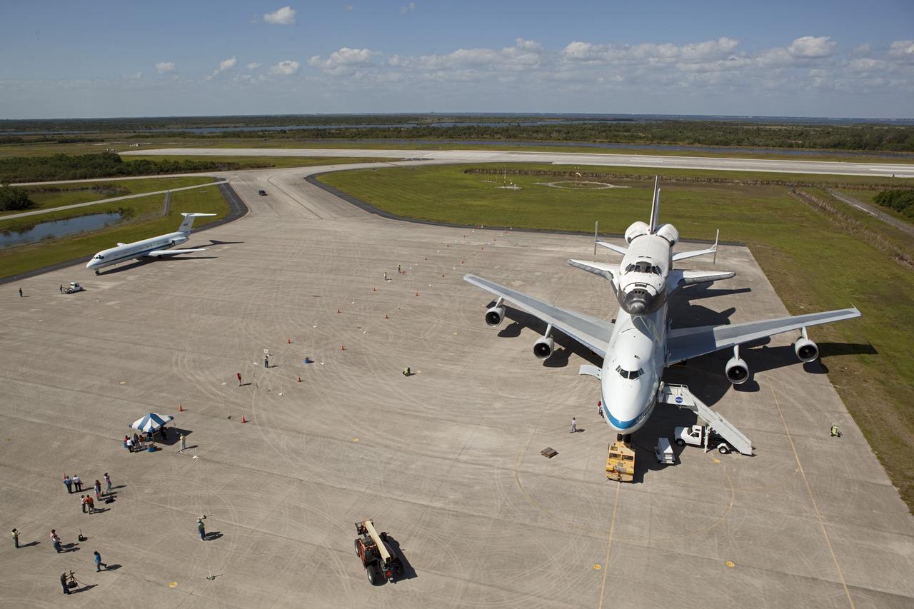 CAPE CANAVERAL, Fla. – The “pathfinder” aircraft for space shuttle Discovery’s ferry flight pulls up beside the Shuttle Carrier Aircraft on the apron of the Shuttle Landing Facility at NASA’s Kennedy Space Center in Florida. The NASA C-9 aircraft will fly about 100 miles ahead of Discovery to scout for the safest route between destinations. Its crew includes an SCA flight engineer who studies the weather patterns along the flight path to find a route free of rain and other turbulence. The carrier aircraft, also known as an SCA, is a Boeing 747 jet, originally manufactured for commercial use which was modified by NASA to transport the shuttles between destinations on Earth. NASA 905 is scheduled to ferry Discovery to the Washington Dulles International Airport in Virginia on April 17, and is assigned to all remaining ferry missions, delivering the shuttles to their permanent public display sites. After its arrival at Dulles, Discovery will be placed on display in the Smithsonian's National Air and Space Museum Steven F. Udvar-Hazy Center on April 19. For more information on the SCA, visit http://www.nasa.gov/centers/dryden/news/FactSheets/FS-013-DFRC.html. For more information on shuttle transition and retirement activities, visit http://www.nasa.gov/transition. Photo credit: NASA/Dimitri Gerondidaki