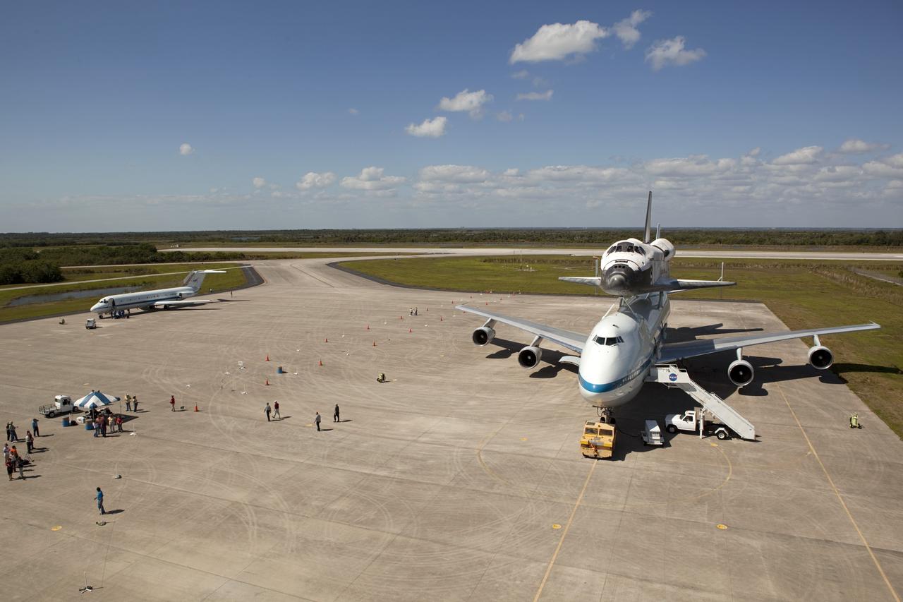 CAPE CANAVERAL, Fla. – The “pathfinder” aircraft for space shuttle Discovery’s ferry flight parks near the Shuttle Carrier Aircraft on the apron of the Shuttle Landing Facility at NASA’s Kennedy Space Center in Florida. The NASA C-9 aircraft will fly about 100 miles ahead of Discovery to scout for the safest route between destinations. Its crew includes an SCA flight engineer who studies the weather patterns along the flight path to find a route free of rain and other turbulence. The carrier aircraft, also known as an SCA, is a Boeing 747 jet, originally manufactured for commercial use which was modified by NASA to transport the shuttles between destinations on Earth. NASA 905 is scheduled to ferry Discovery to the Washington Dulles International Airport in Virginia on April 17, and is assigned to all remaining ferry missions, delivering the shuttles to their permanent public display sites. After its arrival at Dulles, Discovery will be placed on display in the Smithsonian's National Air and Space Museum Steven F. Udvar-Hazy Center on April 19. For more information on the SCA, visit http://www.nasa.gov/centers/dryden/news/FactSheets/FS-013-DFRC.html. For more information on shuttle transition and retirement activities, visit http://www.nasa.gov/transition. Photo credit: NASA/Dimitri Gerondidaki