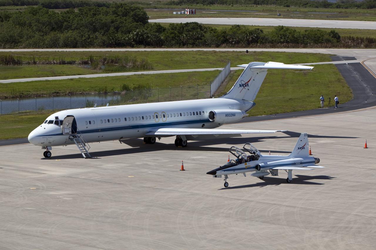 CAPE CANAVERAL, Fla. – A T-38 jet parks beside the “pathfinder” aircraft for space shuttle Discovery’s ferry flight on the apron of the Shuttle Landing Facility at NASA’s Kennedy Space Center in Florida. The NASA C-9 aircraft will fly about 100 miles ahead of Discovery to scout for the safest route between destinations. Its crew includes an SCA flight engineer who studies the weather patterns along the flight path to find a route free of rain and other turbulence. The carrier aircraft, also known as an SCA, is a Boeing 747 jet, originally manufactured for commercial use which was modified by NASA to transport the shuttles between destinations on Earth. NASA 905 is scheduled to ferry Discovery to the Washington Dulles International Airport in Virginia on April 17, and is assigned to all remaining ferry missions, delivering the shuttles to their permanent public display sites. After its arrival at Dulles, Discovery will be placed on display in the Smithsonian's National Air and Space Museum Steven F. Udvar-Hazy Center on April 19. For more information on the SCA, visit http://www.nasa.gov/centers/dryden/news/FactSheets/FS-013-DFRC.html. For more information on shuttle transition and retirement activities, visit http://www.nasa.gov/transition. Photo credit: NASA/Dimitri Gerondidaki