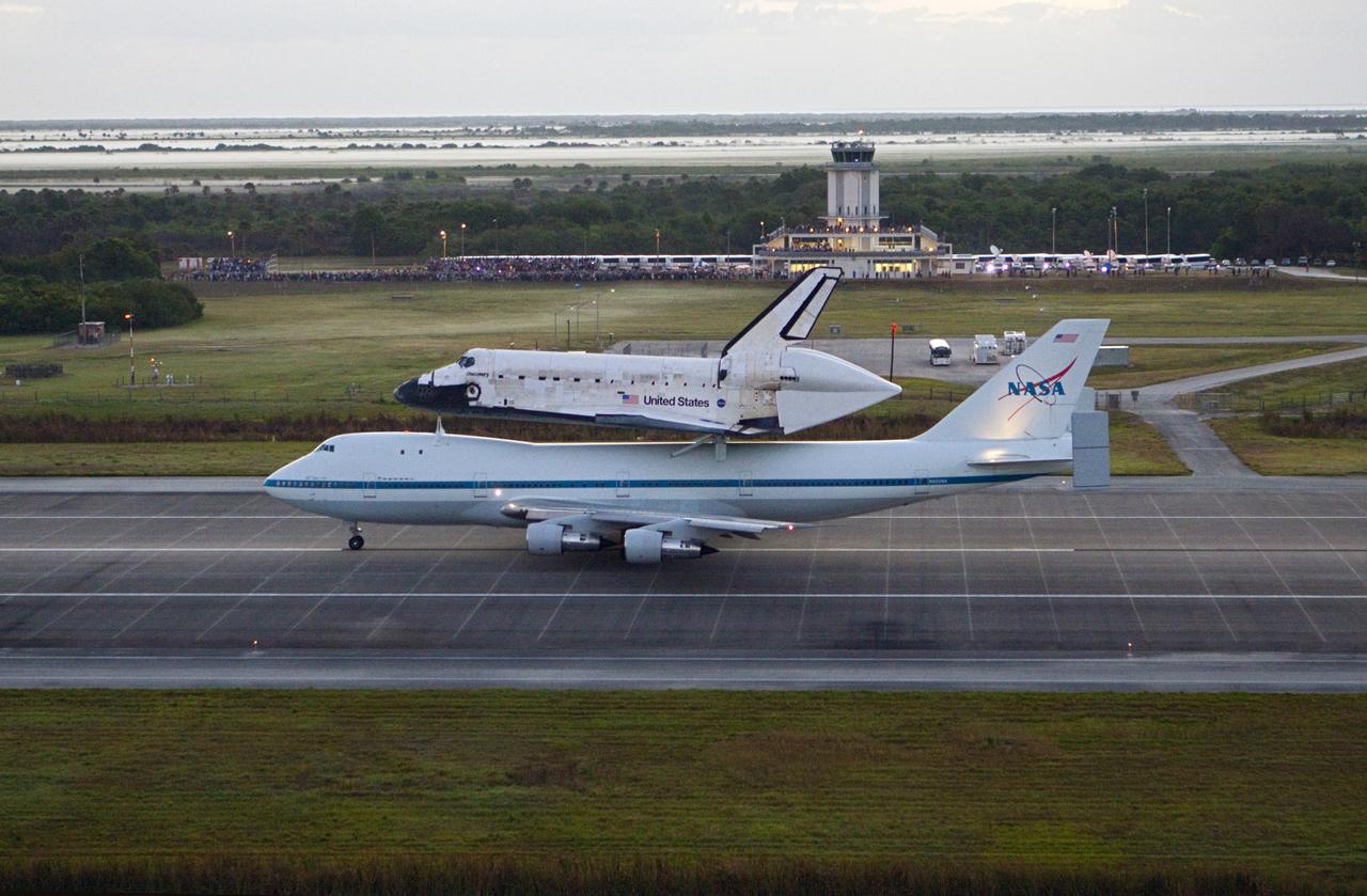 CAPE CANAVERAL, Fla. – In the early morning hours at NASA Kennedy Space Center’s Shuttle Landing Facility in Florida, the Shuttle Carrier Aircraft, or SCA, with space shuttle Discovery secured atop, taxies down the runway for a takeoff at 7 a.m. EDT. In the background is the midfield air traffic control tower. The aircraft, known as an SCA, is a Boeing 747 jet, originally manufactured for commercial use, which was modified by NASA to transport the shuttles between destinations on Earth. This SCA, designated NASA 905, is assigned to the remaining ferry missions, delivering the shuttles to their permanent public display sites. NASA 905 is scheduled to ferry Discovery to the Washington Dulles International Airport in Virginia on April 17, after which the shuttle will be placed on display in the Smithsonian’s National Air and Space Museum, Steven F. Udvar-Hazy Center in Chantilly, Va. For more information on the SCA, visit http://www.nasa.gov/centers/dryden/news/FactSheets/FS-013-DFRC.html. For more information on shuttle transition and retirement activities, visit http://www.nasa.gov/transition. Photo credit: NASA/Glenn Benson