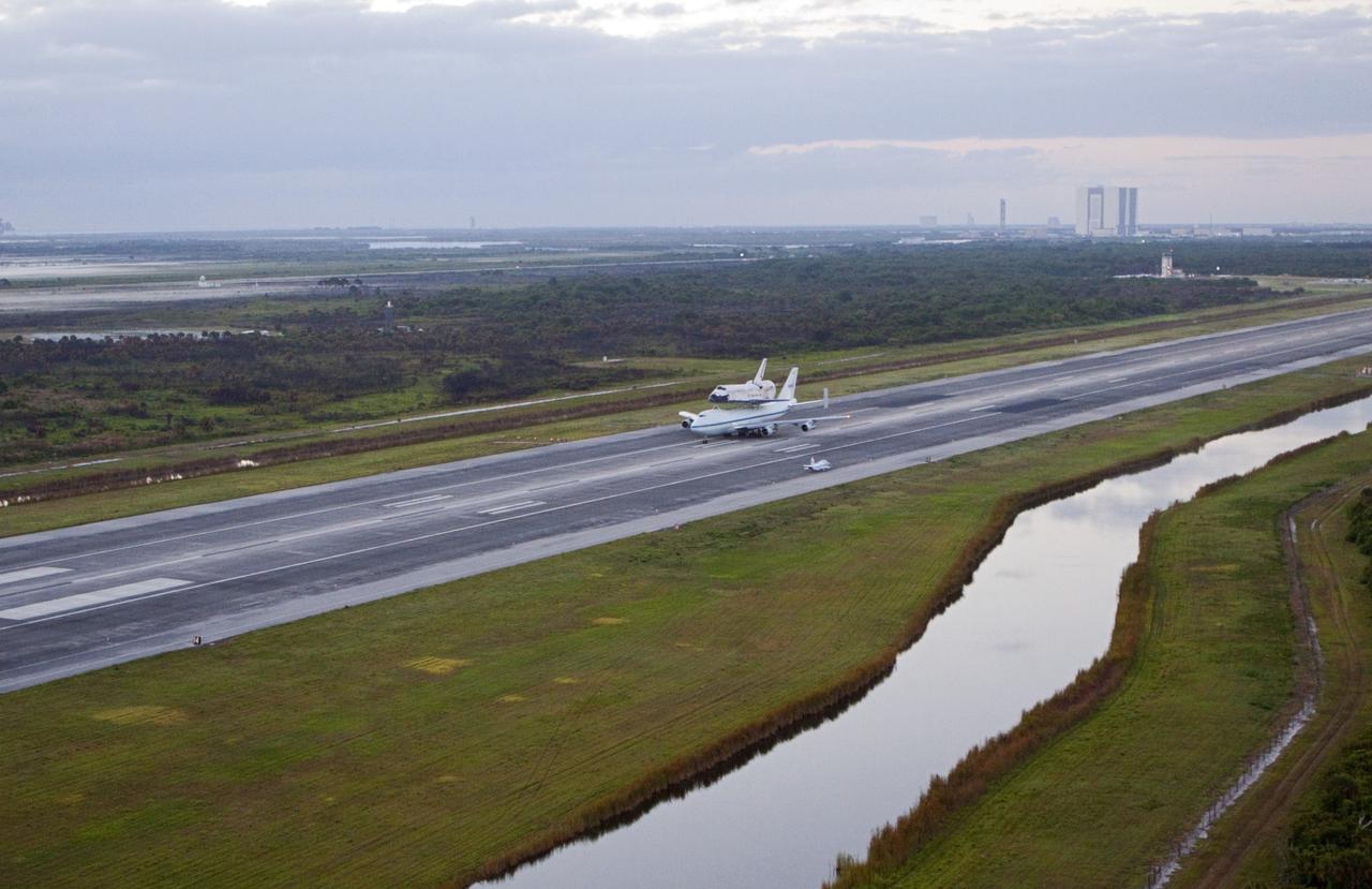 CAPE CANAVERAL, Fla. – In the early morning hours at NASA Kennedy Space Center’s Shuttle Landing Facility in Florida, the Shuttle Carrier Aircraft, or SCA, with space shuttle Discovery secured atop, taxies down the runway for a takeoff at 7 a.m. EDT. In the background is the 525-foot-tall Vehicle Assembly Building. The aircraft, known as an SCA, is a Boeing 747 jet, originally manufactured for commercial use, which was modified by NASA to transport the shuttles between destinations on Earth. This SCA, designated NASA 905, is assigned to the remaining ferry missions, delivering the shuttles to their permanent public display sites. NASA 905 is scheduled to ferry Discovery to the Washington Dulles International Airport in Virginia on April 17, after which the shuttle will be placed on display in the Smithsonian’s National Air and Space Museum, Steven F. Udvar-Hazy Center in Chantilly, Va. For more information on the SCA, visit http://www.nasa.gov/centers/dryden/news/FactSheets/FS-013-DFRC.html. For more information on shuttle transition and retirement activities, visit http://www.nasa.gov/transition. Photo credit: NASA/Glenn Benson