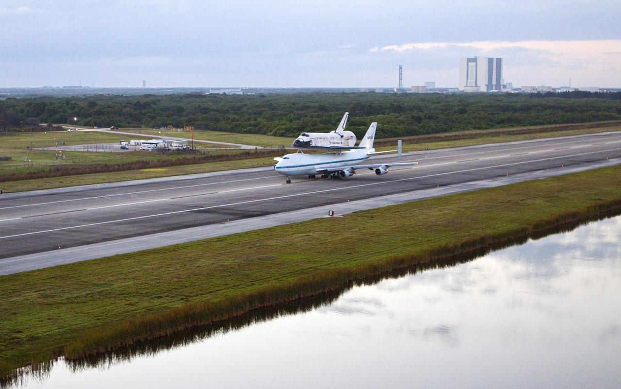 CAPE CANAVERAL, Fla. – In the early morning hours at NASA Kennedy Space Center’s Shuttle Landing Facility in Florida, the Shuttle Carrier Aircraft, or SCA, with space shuttle Discovery secured atop, taxies down the runway for a takeoff at 7 a.m. EDT. In the background is the 525-foot-tall Vehicle Assembly Building. The aircraft, known as an SCA, is a Boeing 747 jet, originally manufactured for commercial use, which was modified by NASA to transport the shuttles between destinations on Earth. This SCA, designated NASA 905, is assigned to the remaining ferry missions, delivering the shuttles to their permanent public display sites. NASA 905 is scheduled to ferry Discovery to the Washington Dulles International Airport in Virginia on April 17, after which the shuttle will be placed on display in the Smithsonian’s National Air and Space Museum, Steven F. Udvar-Hazy Center in Chantilly, Va. For more information on the SCA, visit http://www.nasa.gov/centers/dryden/news/FactSheets/FS-013-DFRC.html. For more information on shuttle transition and retirement activities, visit http://www.nasa.gov/transition. Photo credit: NASA/Glenn Benson