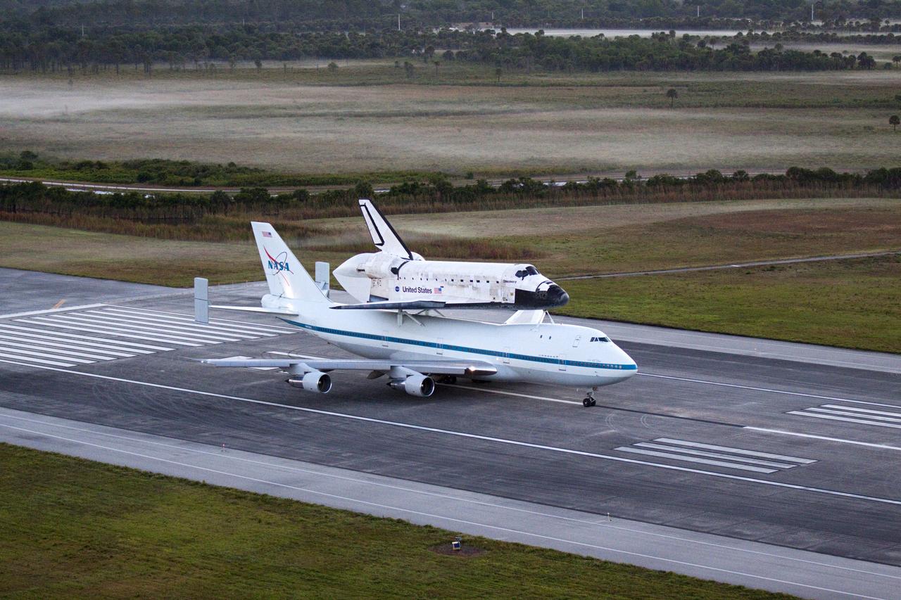 CAPE CANAVERAL, Fla. – In the early morning hours at NASA Kennedy Space Center’s Shuttle Landing Facility in Florida, the Shuttle Carrier Aircraft, or SCA, with space shuttle Discovery secured atop, waits on runway 15 for clearance from Kennedy’s air traffic control tower to begin takeoff at 7 a.m. EDT. The SCA will deliver Discovery to its new home. The aircraft, known as an SCA, is a Boeing 747 jet, originally manufactured for commercial use, which was modified by NASA to transport the shuttles between destinations on Earth. This SCA, designated NASA 905, is assigned to the remaining ferry missions, delivering the shuttles to their permanent public display sites. NASA 905 is scheduled to ferry Discovery to the Washington Dulles International Airport in Virginia on April 17, after which the shuttle will be placed on display in the Smithsonian’s National Air and Space Museum, Steven F. Udvar-Hazy Center in Chantilly, Va. For more information on the SCA, visit http://www.nasa.gov/centers/dryden/news/FactSheets/FS-013-DFRC.html. For more information on shuttle transition and retirement activities, visit http://www.nasa.gov/transition. Photo credit: NASA/Glenn Benson