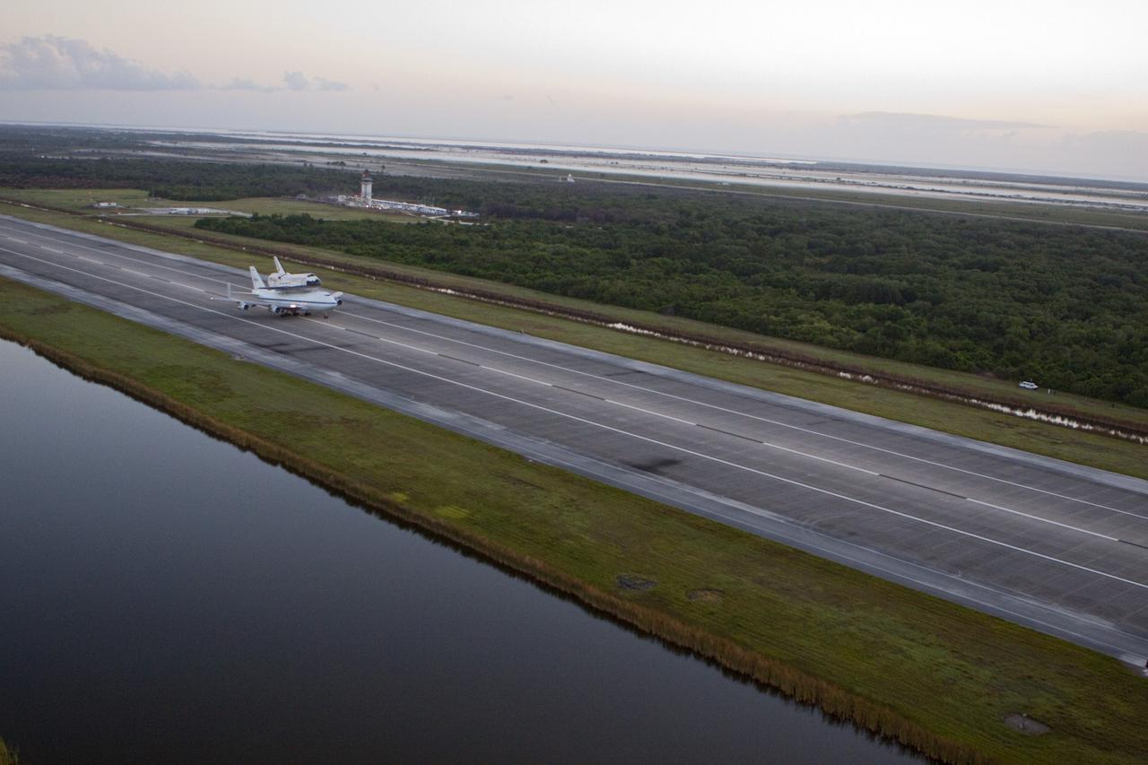 CAPE CANAVERAL, Fla. – In the early morning hours at NASA Kennedy Space Center’s Shuttle Landing Facility in Florida, the Shuttle Carrier Aircraft, or SCA, with space shuttle Discovery secured atop, begins takeoff from runway 15 at 7 a.m. EDT on its way to deliver Discovery to its new home. The aircraft, known as an SCA, is a Boeing 747 jet, originally manufactured for commercial use, which was modified by NASA to transport the shuttles between destinations on Earth. This SCA, designated NASA 905, is assigned to the remaining ferry missions, delivering the shuttles to their permanent public display sites. NASA 905 is scheduled to ferry Discovery to the Washington Dulles International Airport in Virginia on April 17, after which the shuttle will be placed on display in the Smithsonian’s National Air and Space Museum, Steven F. Udvar-Hazy Center in Chantilly, Va. For more information on the SCA, visit http://www.nasa.gov/centers/dryden/news/FactSheets/FS-013-DFRC.html. For more information on shuttle transition and retirement activities, visit http://www.nasa.gov/transition. Photo credit: NASA/Glenn Benson
