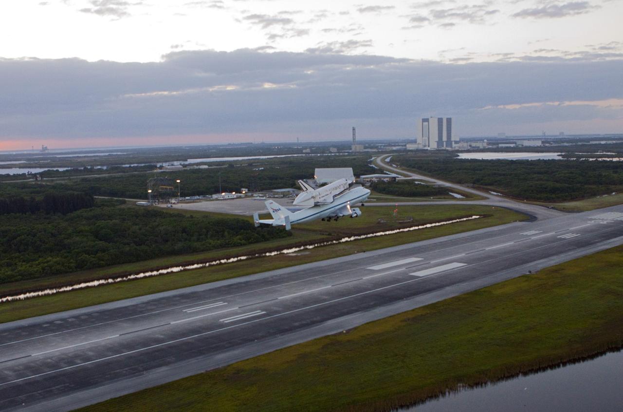 CAPE CANAVERAL, Fla. – The Shuttle Carrier Aircraft transporting space shuttle Discovery to its new home takes off from the Shuttle Landing Facility at NASA’s Kennedy Space Center in Florida at 7 a.m. EDT. In the background is the 525-foot-tall Vehicle Assembly Building and NASA’s new mobile launcher. The aircraft, known as an SCA, is a Boeing 747 jet, originally manufactured for commercial use, which was modified by NASA to transport the shuttles between destinations on Earth. This SCA, designated NASA 905, is assigned to the remaining ferry missions, delivering the shuttles to their permanent public display sites. NASA 905 is scheduled to ferry Discovery to the Washington Dulles International Airport in Virginia on April 17, after which the shuttle will be placed on display in the Smithsonian's National Air and Space Museum Steven F. Udvar-Hazy Center. For more information on the SCA, visit http://www.nasa.gov/centers/dryden/news/FactSheets/FS-013-DFRC.html. For more information on shuttle transition and retirement activities, visit http://www.nasa.gov/transition. Photo credit: NASA/Glenn Benson