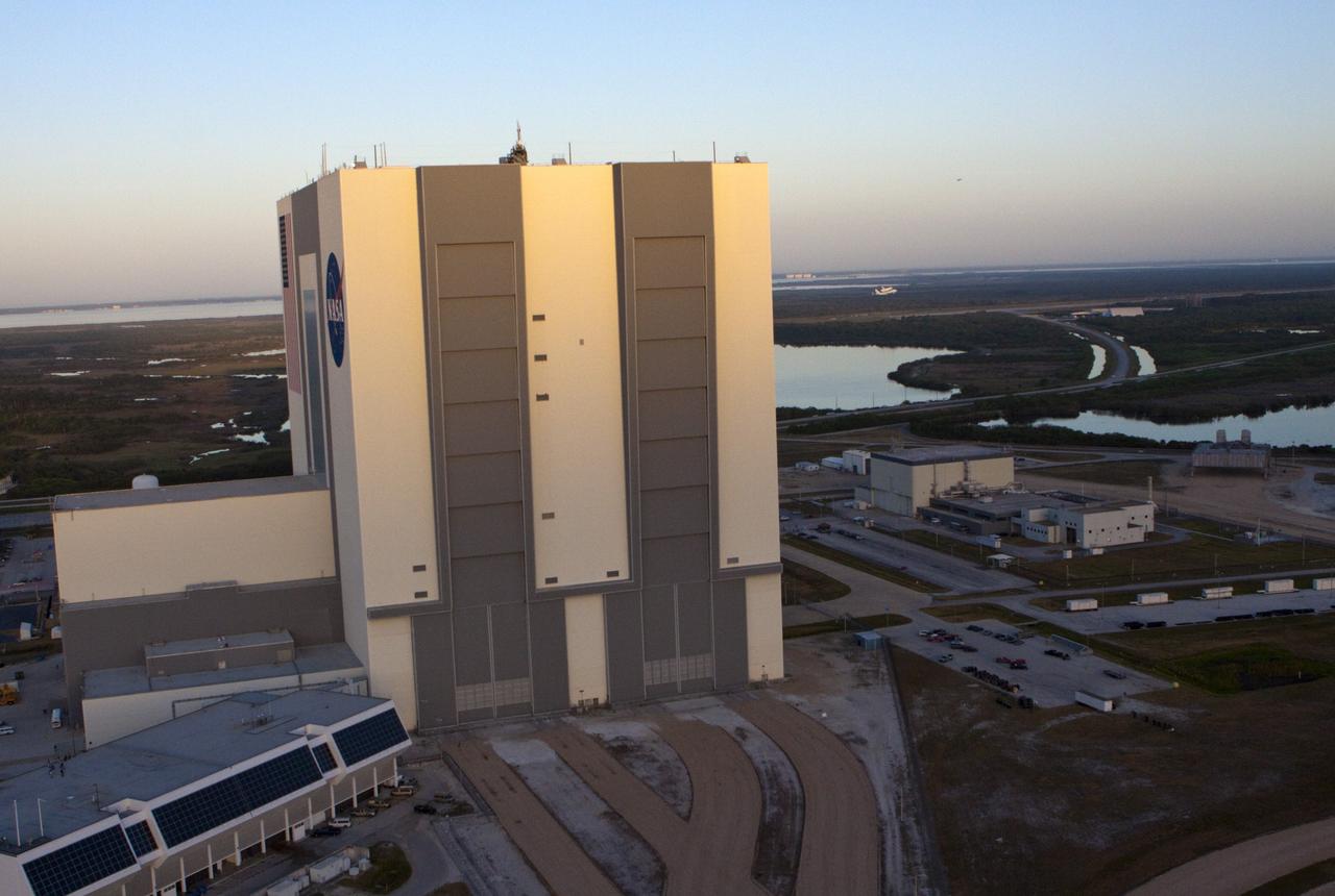 CAPE CANAVERAL, Fla. – At the right side of this aerial photo, near the horizon, the Shuttle Carrier Aircraft transporting space shuttle Discovery to its new home flies past the 525-foot-tall Vehicle Assembly Building at NASA’s Kennedy Space Center in Florida. The duo took off from Kennedy’s Shuttle Landing Facility at 7 a.m. EDT. The aircraft, known as an SCA, is a Boeing 747 jet, originally manufactured for commercial use, which was modified by NASA to transport the shuttles between destinations on Earth. This SCA, designated NASA 905, is assigned to the remaining ferry missions, delivering the shuttles to their permanent public display sites. NASA 905 is scheduled to ferry Discovery to the Washington Dulles International Airport in Virginia today, after which the shuttle will be placed on display in the Smithsonian's National Air and Space Museum Steven F. Udvar-Hazy Center. For more information on the SCA, visit http://www.nasa.gov/centers/dryden/news/FactSheets/FS-013-DFRC.html. For more information on shuttle transition and retirement activities, visit http://www.nasa.gov/transition. Photo credit: NASA/Glenn Benson