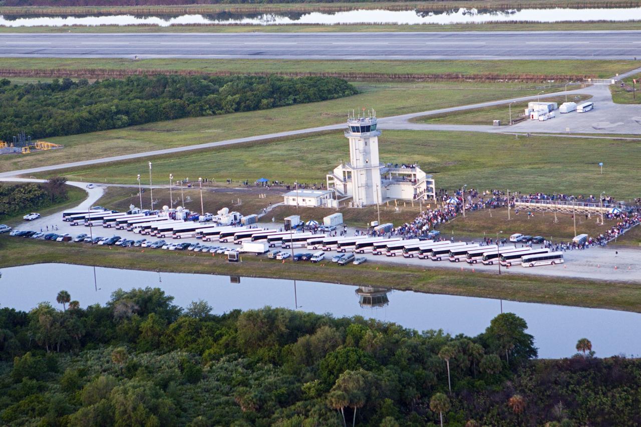 CAPE CANAVERAL, Fla. – Buses line the parking lot beside the control tower at the Shuttle Landing Facility at NASA’s Kennedy Space Center in Florida. Kennedy employees and guests were on hand at 7 a.m. EDT to witness the departure of the Shuttle Carrier Aircraft transporting space shuttle Discovery to its new home. The aircraft, known as an SCA, is a Boeing 747 jet, originally manufactured for commercial use, which was modified by NASA to transport the shuttles between destinations on Earth. This SCA, designated NASA 905, is assigned to the remaining ferry missions, delivering the shuttles to their permanent public display sites. NASA 905 is scheduled to ferry Discovery to the Washington Dulles International Airport in Virginia today, after which the shuttle will be placed on display in the Smithsonian's National Air and Space Museum Steven F. Udvar-Hazy Center. For more information on the SCA, visit http://www.nasa.gov/centers/dryden/news/FactSheets/FS-013-DFRC.html. For more information on shuttle transition and retirement activities, visit http://www.nasa.gov/transition. Photo credit: NASA/Glenn Benson