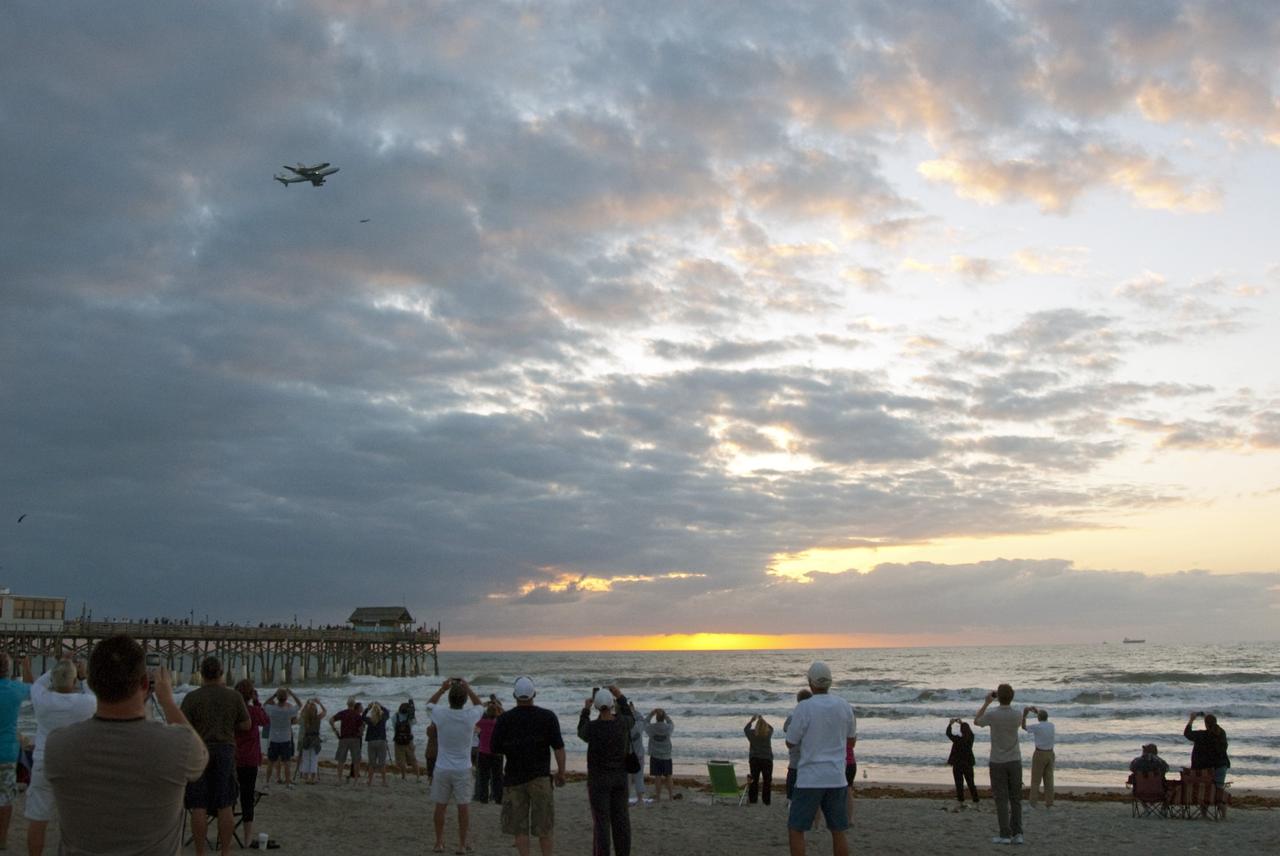 CAPE CANAVERAL, Fla. – The Shuttle Carrier Aircraft transporting space shuttle Discovery, accompanied by a T-38 jet, flies over the Cocoa Beach pier just after sunrise, giving Brevard County residents the opportunity to see the shuttle for the last time before it leaves the Space Coast for its new home. The aircraft, known as an SCA, is a Boeing 747 jet, originally manufactured for commercial use which was modified by NASA to transport the shuttles between destinations on Earth. This SCA, designated NASA 905, is assigned to the remaining ferry missions, delivering the shuttles to their permanent public display sites. NASA 905 is ferrying Discovery to the Washington Dulles International Airport in Virginia today, after which the shuttle will be placed on display in the Smithsonian's National Air and Space Museum Steven F. Udvar-Hazy Center around April 19. For more information on the SCA, visit http://www.nasa.gov/centers/dryden/news/FactSheets/FS-013-DFRC.html. For more information on shuttle transition and retirement activities, visit http://www.nasa.gov/transition. Photo credit: NASA/R. D. Lee