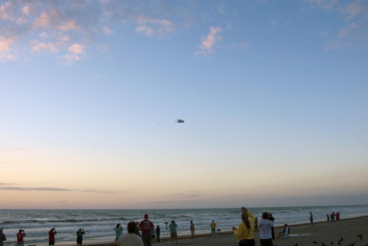 CAPE CANAVERAL, Fla. – Just after sunrise, visitors to Cocoa Beach catch a final glimpse of the Shuttle Carrier Aircraft transporting space shuttle Discovery from the Space Coast to its new home in Virginia. The aircraft, known as an SCA, is a Boeing 747 jet, originally manufactured for commercial use which was modified by NASA to transport the shuttles between destinations on Earth. This SCA, designated NASA 905, is assigned to the remaining ferry missions, delivering the shuttles to their permanent public display sites. NASA 905 is ferrying Discovery to the Washington Dulles International Airport in Virginia today, after which the shuttle will be placed on display in the Smithsonian's National Air and Space Museum Steven F. Udvar-Hazy Center around April 19. For more information on the SCA, visit http://www.nasa.gov/centers/dryden/news/FactSheets/FS-013-DFRC.html. For more information on shuttle transition and retirement activities, visit http://www.nasa.gov/transition. Photo credit: NASA/R. D. Lee