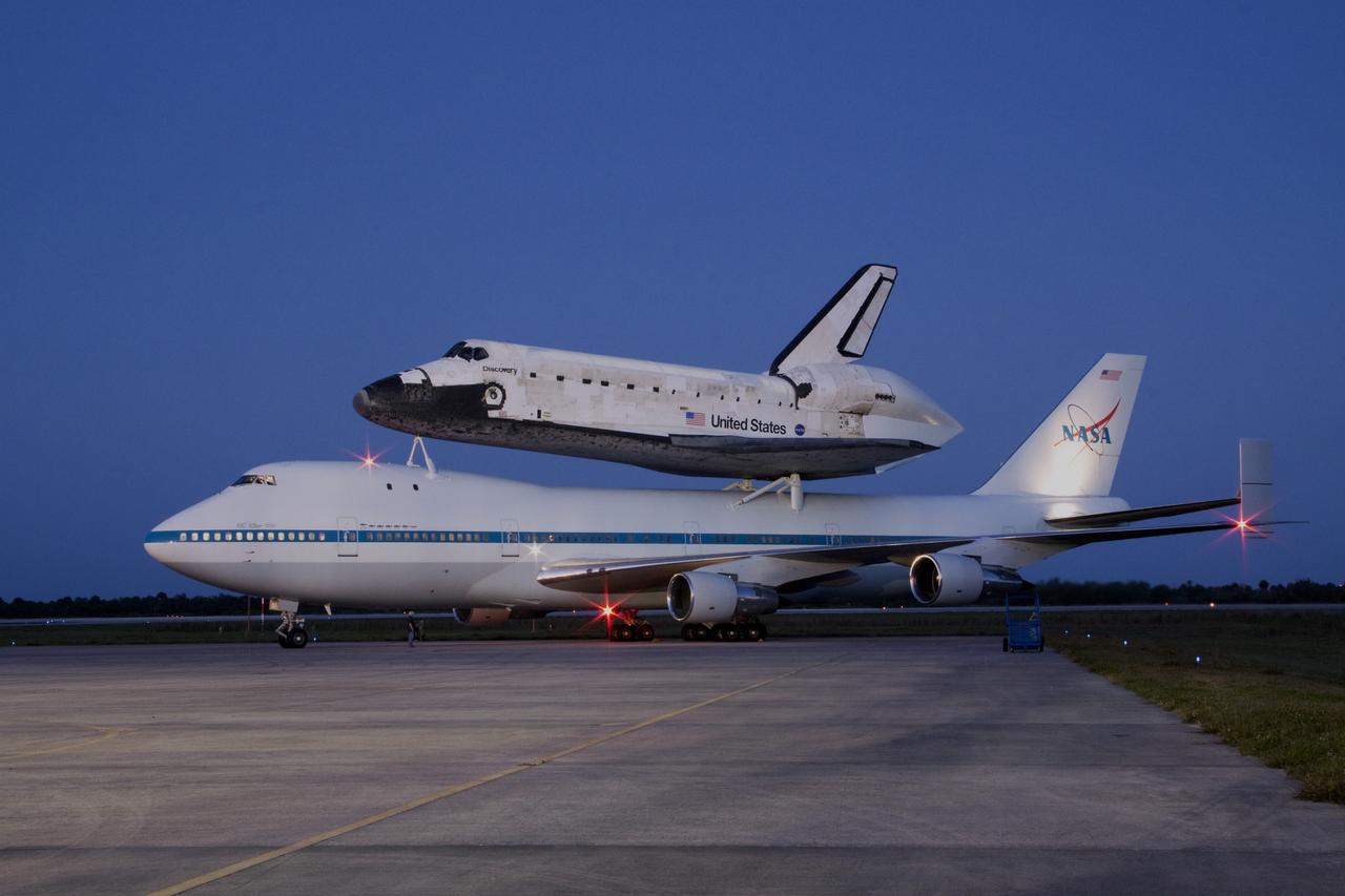 CAPE CANAVERAL, Fla. – Space shuttle Discovery, mounted to a Shuttle Carrier Aircraft, is illumined just before dawn on the ramp of the Shuttle Landing Facility at NASA's Kennedy Space Center in Florida. The duo is set to begin their 3 1/2 hour ferry flight to the Washington Dulles International Airport in Virginia at about 7 a.m. EDT. Discovery is leaving Kennedy after more than 28 years of service beginning with its arrival on the space coast Nov. 9, 1983. Discovery first launched to space Aug. 30, 1984, on the STS-41D mission. Discovery is the agency's most-flown shuttle with 39 missions, more than 148 million miles and a total of one year in space. Discovery is set to move to the Smithsonian's National Air and Space Museum Steven F. Udvar-Hazy Center on April 19 where it will be placed on public display. For more information on the SCA, visit http://www.nasa.gov/centers/dryden/news/FactSheets/FS-013-DFRC.html. For more information on shuttle transition and retirement activities, visit http://www.nasa.gov/transition. Photo credit: NASA/Jim Grossmann