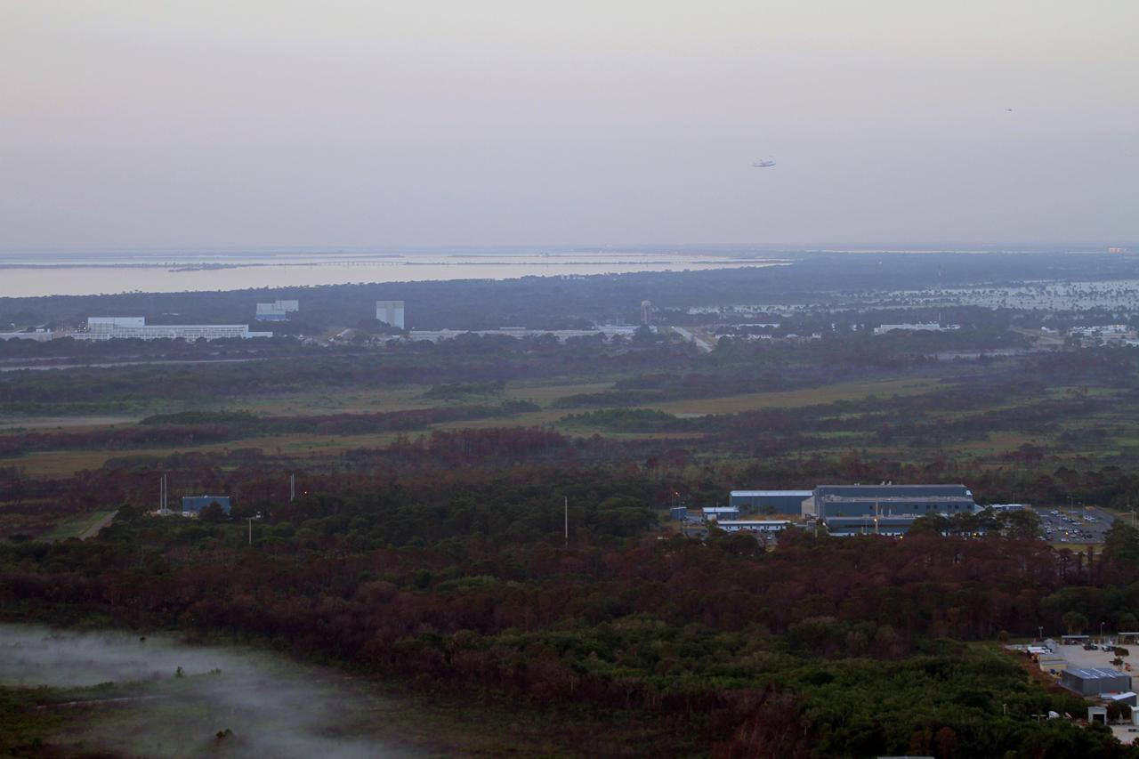 CAPE CANAVERAL, Fla. – The Shuttle Carrier Aircraft transporting space shuttle Discovery to its new home flies over NASA Kennedy Space Center’s Industrial Area after taking off from the Shuttle Landing Facility at 7 a.m. EDT. The blue building in the foreground is the Assembly and Rotation Facility. The duo are heading south to fly over Brevard County’s beach communities for residents to get a look at the shuttle before it leaves the Space Coast for the last time. The aircraft, known as an SCA, is a Boeing 747 jet, originally manufactured for commercial use, which was modified by NASA to transport the shuttles between destinations on Earth. This SCA, designated NASA 905, is assigned to the remaining ferry missions, delivering the shuttles to their permanent public display sites. NASA 905 is scheduled to ferry Discovery to the Washington Dulles International Airport in Virginia on April 17, after which the shuttle will be placed on display in the Smithsonian's National Air and Space Museum Steven F. Udvar-Hazy Center. For more information on the SCA, visit http://www.nasa.gov/centers/dryden/news/FactSheets/FS-013-DFRC.html. For more information on shuttle transition and retirement activities, visit http://www.nasa.gov/transition. Photo credit: NASA/Lorne Mathre