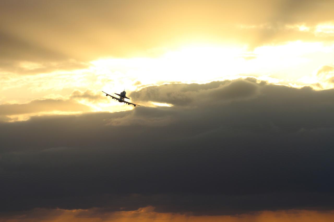 CAPE CANAVERAL, Fla. – The Shuttle Carrier Aircraft transporting space shuttle Discovery to its new home heads into the sunrise as it departs from NASA’s Kennedy Space Center in Florida at 7 a.m. EDT. The duo are heading south to fly over Brevard County’s beach communities, offering residents the opportunity to see the shuttle before it leaves the Space Coast for the last time. The aircraft, known as an SCA, is a Boeing 747 jet, originally manufactured for commercial use, which was modified by NASA to transport the shuttles between destinations on Earth. This SCA, designated NASA 905, is assigned to the remaining ferry missions, delivering the shuttles to their permanent public display sites. NASA 905 is scheduled to ferry Discovery to the Washington Dulles International Airport in Virginia on April 17, after which the shuttle will be placed on display in the Smithsonian's National Air and Space Museum Steven F. Udvar-Hazy Center. For more information on the SCA, visit http://www.nasa.gov/centers/dryden/news/FactSheets/FS-013-DFRC.html. For more information on shuttle transition and retirement activities, visit http://www.nasa.gov/transition. Photo credit: NASA/Lorne Mathre