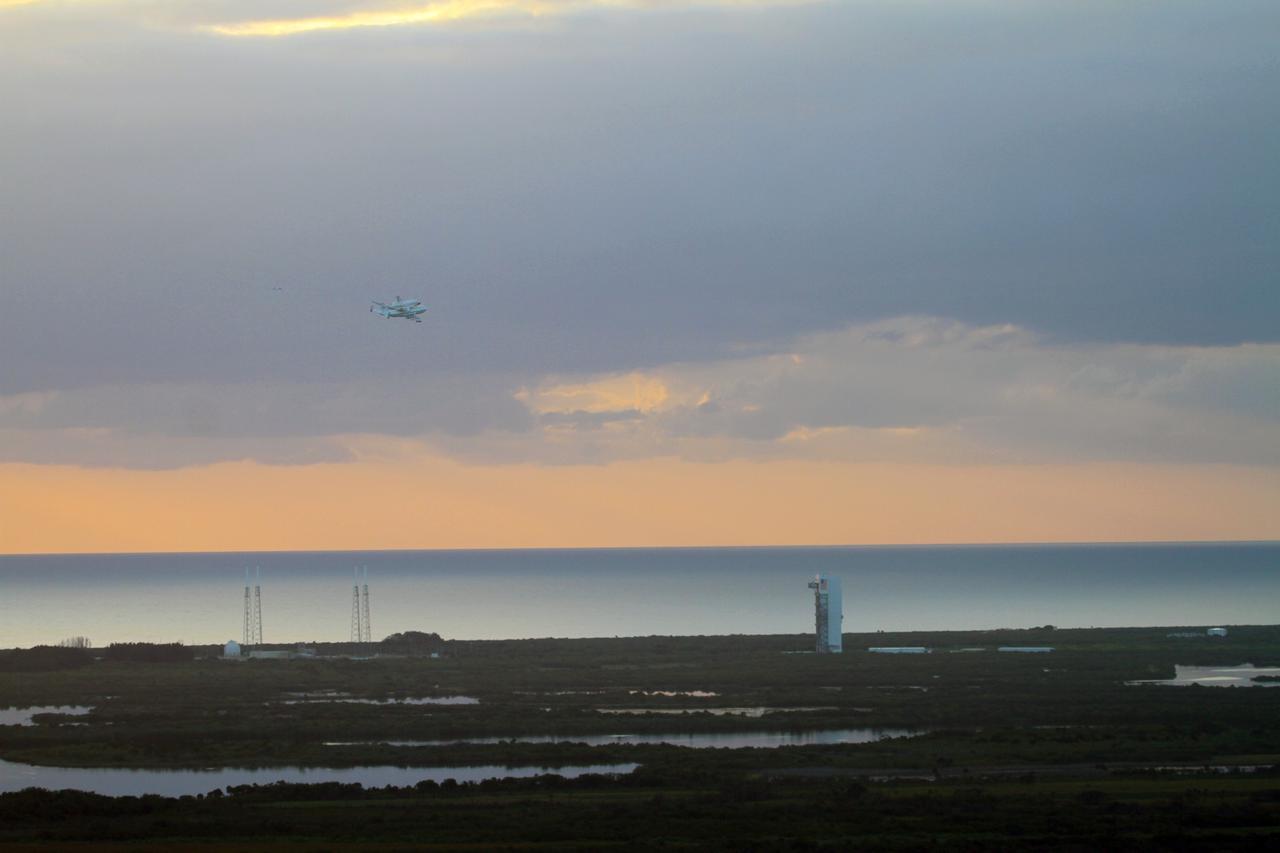 CAPE CANAVERAL, Fla. – The Shuttle Carrier Aircraft transporting space shuttle Discovery flies over the Vertical Integration Facility at Space Launch Complex-41 on Cape Canaveral Air Force Station after taking off from Kennedy Space Center’s Shuttle Landing Facility at 7 a.m. EDT. The duo are heading south to fly over Brevard County’s beach communities, offering residents the opportunity to see the shuttle before it leaves the Space Coast for the last time.     The aircraft, known as an SCA, is a Boeing 747 jet, originally manufactured for commercial use, which was modified by NASA to transport the shuttles between destinations on Earth. This SCA, designated NASA 905, is assigned to the remaining ferry missions, delivering the shuttles to their permanent public display sites.  NASA 905 is scheduled to ferry Discovery to the Washington Dulles International Airport in Virginia on April 17, after which the shuttle will be placed on display in the Smithsonian's National Air and Space Museum Steven F. Udvar-Hazy Center. For more information on the SCA, visit http://www.nasa.gov/centers/dryden/news/FactSheets/FS-013-DFRC.html. For more information on shuttle transition and retirement activities, visit http://www.nasa.gov/transition. Photo credit: NASA/Lorne Mathre