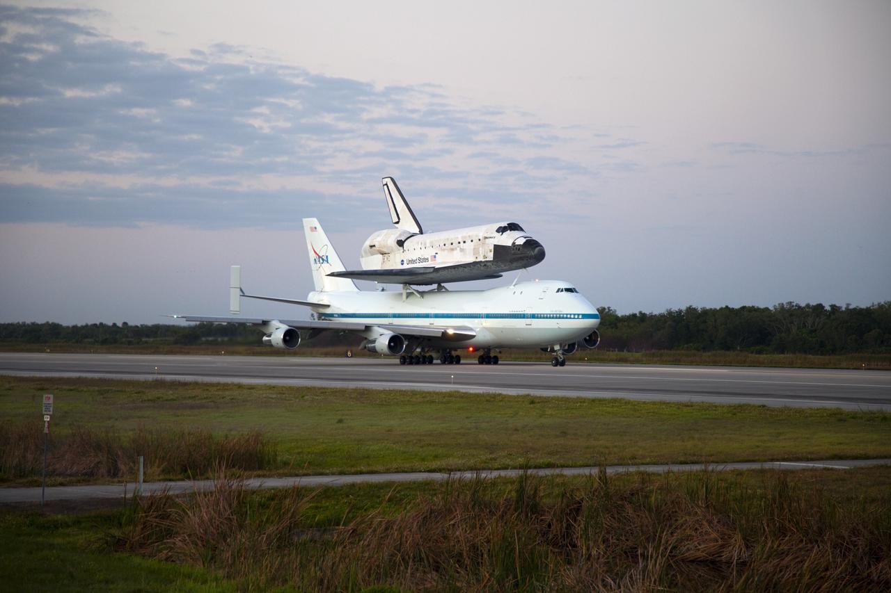 CAPE CANAVERAL, Fla. – Space shuttle Discovery, mounted to a Shuttle Carrier Aircraft, slowly rolls along the runway of the Shuttle Landing Facility at NASA's Kennedy Space Center in Florida. The duo is set to begin their 3 1/2 hour ferry flight to the Washington Dulles International Airport in Virginia at about 7 a.m. EDT. Above the two craft is a NASA helicopter covering the departure. Discovery is leaving Kennedy after more than 28 years of service beginning with its arrival on the space coast Nov. 9, 1983. Discovery first launched to space Aug. 30, 1984, on the STS-41D mission. Discovery is the agency's most-flown shuttle with 39 missions, more than 148 million miles and a total of one year in space. Discovery is set to move to the Smithsonian's National Air and Space Museum Steven F. Udvar-Hazy Center on April 19 where it will be placed on public display. For more information on the SCA, visit http://www.nasa.gov/centers/dryden/news/FactSheets/FS-013-DFRC.html. For more information on shuttle transition and retirement activities, visit http://www.nasa.gov/transition. Photo credit: NASA/Frankie Martin