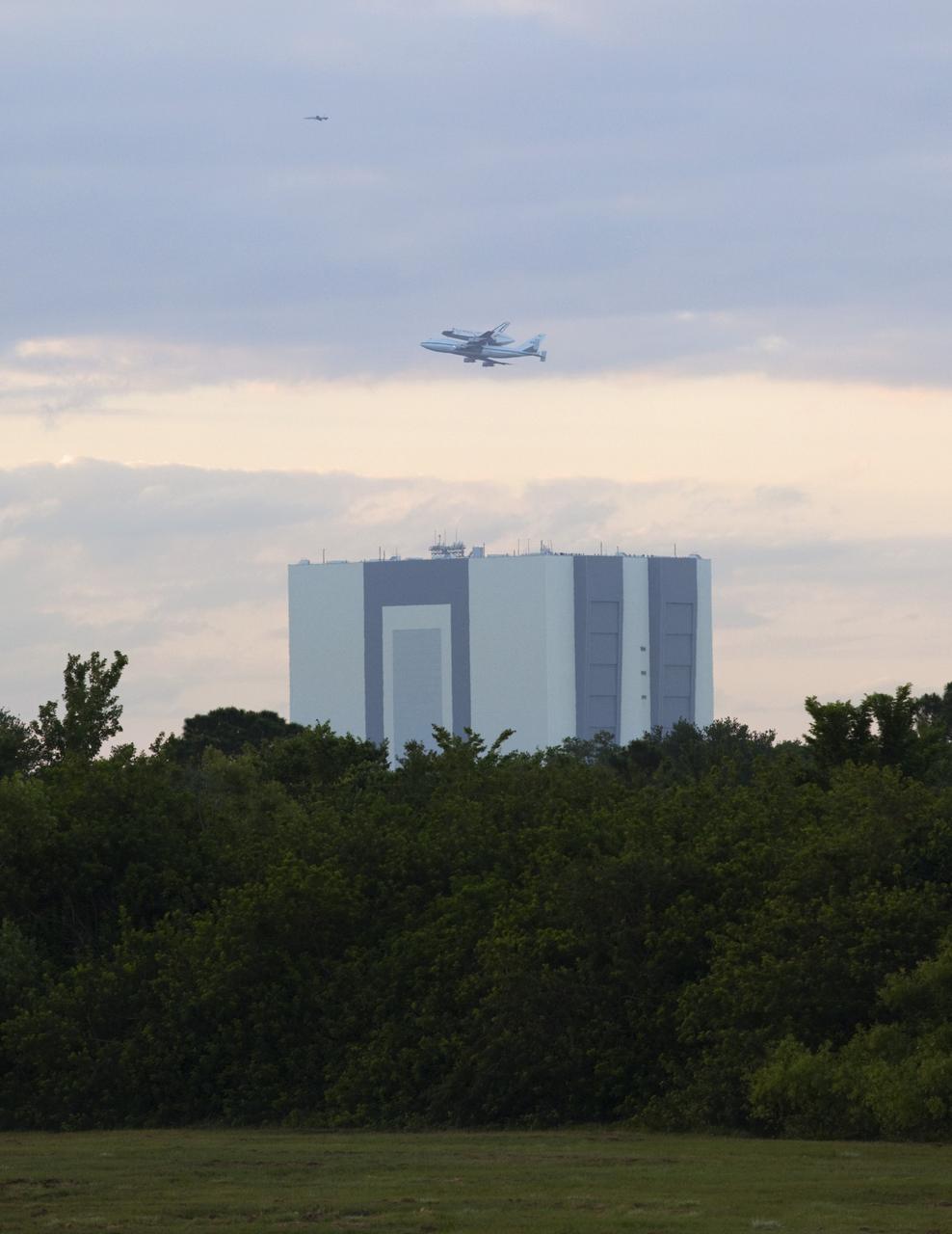 CAPE CANAVERAL, Fla. – Space shuttle Discovery, mounted to a Shuttle Carrier Aircraft, soars past the Vehicle Assembly Building at NASA's Kennedy Space Center in Florida. The duo is beginning their 3 1/2 hour ferry flight to the Washington Dulles International Airport in Virginia. Also flying along with the pair is a T-38 training jet. Discovery is leaving Kennedy after more than 28 years of service beginning with its arrival on the space coast Nov. 9, 1983. Discovery first launched to space Aug. 30, 1984, on the STS-41D mission. Discovery is the agency's most-flown shuttle with 39 missions, more than 148 million miles and a total of one year in space. Discovery is set to move to the Smithsonian's National Air and Space Museum Steven F. Udvar-Hazy Center on April 19 where it will be placed on public display. For more information on the SCA, visit http://www.nasa.gov/centers/dryden/news/FactSheets/FS-013-DFRC.html. For more information on shuttle transition and retirement activities, visit http://www.nasa.gov/transition. Photo credit: NASA/Frankie Martin