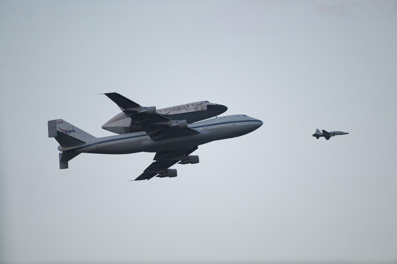 CAPE CANAVERAL, Fla. – Space shuttle Discovery, mounted to a Shuttle Carrier Aircraft, flies over the Shuttle Landing Facility at NASA's Kennedy Space Center in Florida after making a flyby of Cocoa Beach and Patrick Air Force Base. The duo is beginning its ferry flight to the Washington Dulles International Airport in Virginia that also includes a flyby of the Space Coast and Washington, D.C. Also flying along with the pair is a T-38 training jet.  Discovery is leaving Kennedy after more than 28 years of service beginning with its arrival on the space coast Nov. 9, 1983. Discovery first launched to space Aug. 30, 1984, on the STS-41D mission. Discovery is the agency's most-flown shuttle with 39 missions, more than 148 million miles and a total of one year in space.         Discovery is set to move to the Smithsonian's National Air and Space Museum Steven F. Udvar-Hazy Center on April 19 where it will be placed on public display. For more information on the SCA, visit http://www.nasa.gov/centers/dryden/news/FactSheets/FS-013-DFRC.html. For more information on shuttle transition and retirement activities, visit http://www.nasa.gov/transition. Photo credit: NASA/Kenny Allen