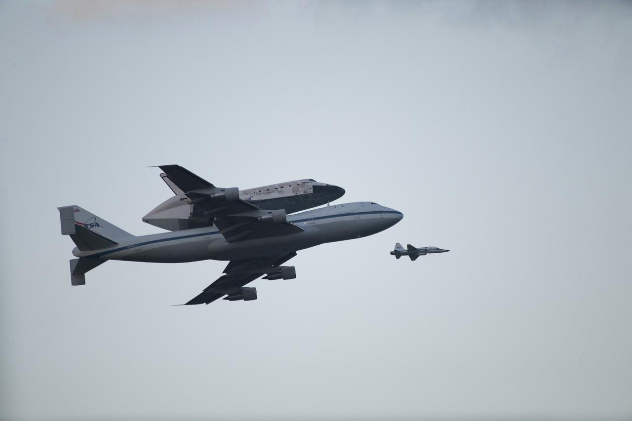CAPE CANAVERAL, Fla. – Space shuttle Discovery, mounted to a Shuttle Carrier Aircraft, flies over the Shuttle Landing Facility at NASA's Kennedy Space Center in Florida after making a flyby of Cocoa Beach and Patrick Air Force Base. The duo is beginning its ferry flight to the Washington Dulles International Airport in Virginia that also includes a flyby of the Space Coast and Washington, D.C. Also flying along with the pair is a T-38 training jet.  Discovery is leaving Kennedy after more than 28 years of service beginning with its arrival on the space coast Nov. 9, 1983. Discovery first launched to space Aug. 30, 1984, on the STS-41D mission. Discovery is the agency's most-flown shuttle with 39 missions, more than 148 million miles and a total of one year in space.     Discovery is set to move to the Smithsonian's National Air and Space Museum Steven F. Udvar-Hazy Center on April 19 where it will be placed on public display. For more information on the SCA, visit http://www.nasa.gov/centers/dryden/news/FactSheets/FS-013-DFRC.html. For more information on shuttle transition and retirement activities, visit http://www.nasa.gov/transition. Photo credit: NASA/Kenny Allen