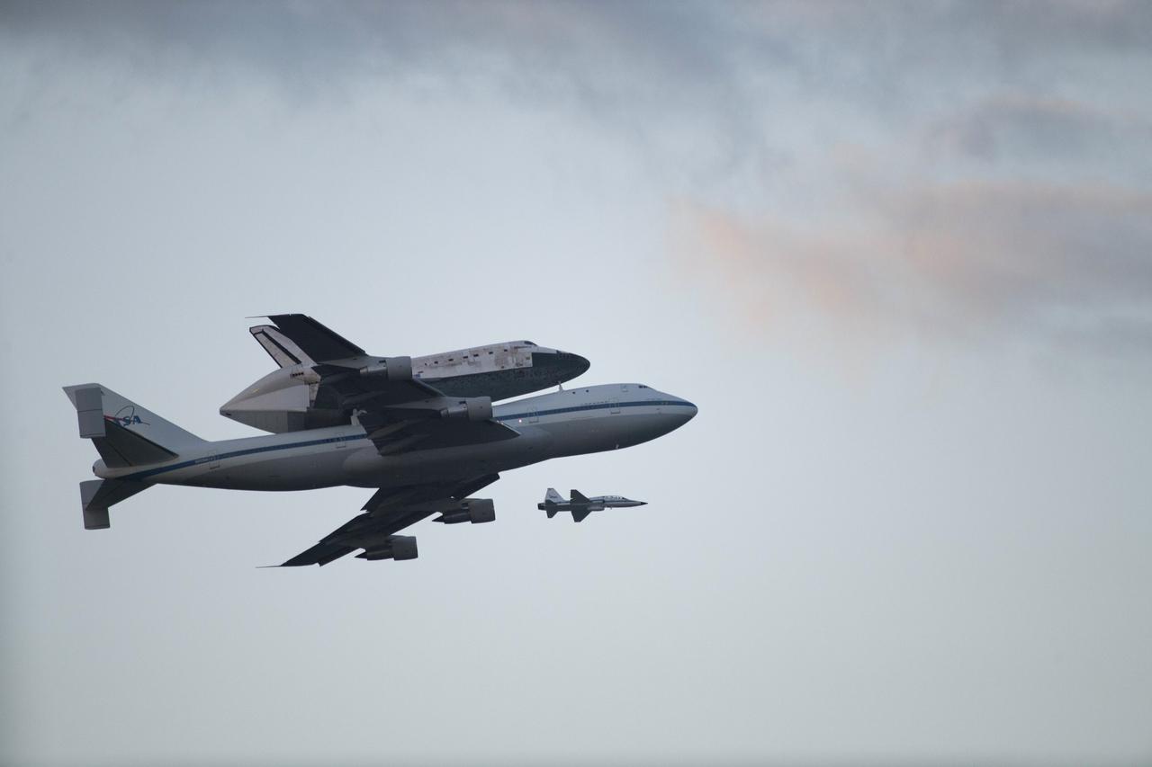 CAPE CANAVERAL, Fla. – Space shuttle Discovery, mounted to a Shuttle Carrier Aircraft, flies over the Shuttle Landing Facility at NASA's Kennedy Space Center in Florida after making a flyby of Cocoa Beach and Patrick Air Force Base. The duo is beginning its ferry flight to the Washington Dulles International Airport in Virginia that also includes a flyby of the Space Coast and Washington, D.C. Also flying along with the pair is a T-38 training jet.  Discovery is leaving Kennedy after more than 28 years of service beginning with its arrival on the space coast Nov. 9, 1983. Discovery first launched to space Aug. 30, 1984, on the STS-41D mission. Discovery is the agency's most-flown shuttle with 39 missions, more than 148 million miles and a total of one year in space.     Discovery is set to move to the Smithsonian's National Air and Space Museum Steven F. Udvar-Hazy Center on April 19 where it will be placed on public display. For more information on the SCA, visit http://www.nasa.gov/centers/dryden/news/FactSheets/FS-013-DFRC.html. For more information on shuttle transition and retirement activities, visit http://www.nasa.gov/transition. Photo credit: NASA/Kenny Allen