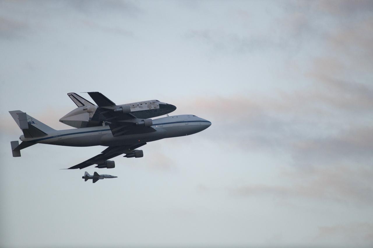 CAPE CANAVERAL, Fla. – Space shuttle Discovery, mounted to a Shuttle Carrier Aircraft, flies over the Shuttle Landing Facility at NASA's Kennedy Space Center in Florida after making a flyby of Cocoa Beach and Patrick Air Force Base. The duo is beginning its ferry flight to the Washington Dulles International Airport in Virginia that also includes a flyby of the Space Coast and Washington, D.C. Also flying along with the pair is a T-38 training jet. Discovery is leaving Kennedy after more than 28 years of service beginning with its arrival on the space coast Nov. 9, 1983. Discovery first launched to space Aug. 30, 1984, on the STS-41D mission. Discovery is the agency's most-flown shuttle with 39 missions, more than 148 million miles and a total of one year in space.     Discovery is set to move to the Smithsonian's National Air and Space Museum Steven F. Udvar-Hazy Center on April 19 where it will be placed on public display. For more information on the SCA, visit http://www.nasa.gov/centers/dryden/news/FactSheets/FS-013-DFRC.html. For more information on shuttle transition and retirement activities, visit http://www.nasa.gov/transition. Photo credit: NASA/Kenny Allen