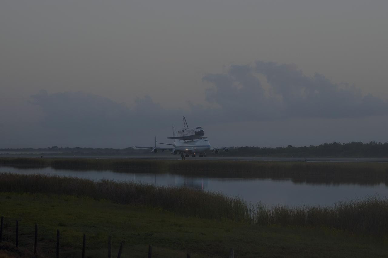 CAPE CANAVERAL, Fla. – In the early morning hours at NASA Kennedy Space Center’s Shuttle Landing Facility in Florida, the Shuttle Carrier Aircraft, or SCA, with space shuttle Discovery secured atop, taxies past the midpoint on its way for a takeoff on runway 15 at 7 a.m. EDT. The aircraft, known as an SCA, is a Boeing 747 jet, originally manufactured for commercial use, which was modified by NASA to transport the shuttles between destinations on Earth. This SCA, designated NASA 905, is assigned to the remaining ferry missions, delivering the shuttles to their permanent public display sites. NASA 905 is scheduled to ferry Discovery to the Washington Dulles International Airport in Virginia on April 17, after which the shuttle will be placed on display in the Smithsonian’s National Air and Space Museum, Steven F. Udvar-Hazy Center in Chantilly, Va. For more information on the SCA, visit http://www.nasa.gov/centers/dryden/news/FactSheets/FS-013-DFRC.html. For more information on shuttle transition and retirement activities, visit http://www.nasa.gov/transition. Photo credit: NASA/Tim Powers and Rick Wetherington