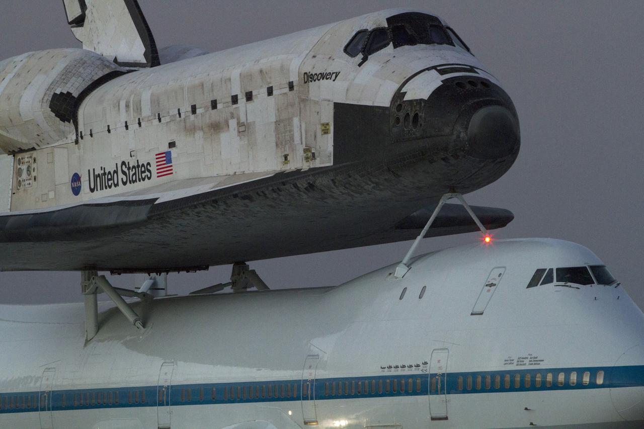 CAPE CANAVERAL, Fla. - Space shuttle Discovery is secured to the top of the Shuttle Carrier Aircraft in anticipation of an early morning takeoff from NASA's Kennedy Space Center in Florida. The duo departed Kennedy's runway 15 at 7 a.m. EDT.    The aircraft, known as an SCA, is a Boeing 747 jet, originally manufactured for commercial use, which was modified by NASA to transport the shuttles between destinations on Earth. This SCA, designated NASA 905, is assigned to the remaining ferry  missions, delivering the shuttles to their permanent public display sites. NASA 905 carried Discovery to the Washington Dulles International Airport in Virginia on April 17, after which the shuttle will be placed on display in the Smithsonian's National Air and Space Museum, Steven F. Udvar-Hazy Center in Chantilly,  Va. For more information on the SCA, visit http://www.nasa.gov/centers/dryden/news/FactSheets/FS-  013-DFRC.html. For more information on shuttle transition and retirement activities, visit  http://www .nasa.gov/transition. Photo credit: NASA/Rusty Backer