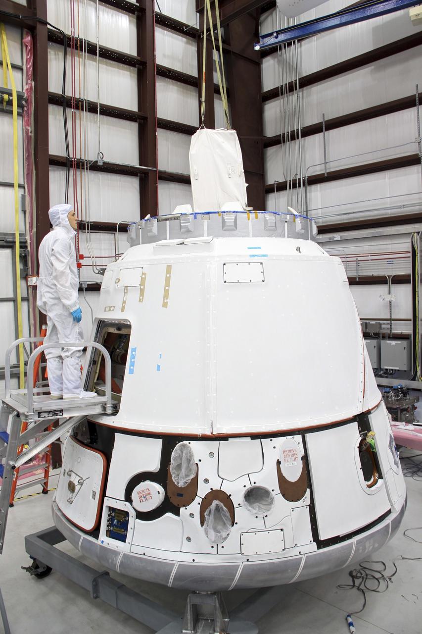 CAPE CANAVERAL, Fla. – In a processing hangar at Space Launch Complex-40 on Cape Canaveral Air Force Station in Florida, a cargo bag slides through the docking ring into the Space Exploration Technologies Dragon capsule for stowage for its scheduled April 30 liftoff aboard a Falcon 9 rocket. Known as SpaceX, the launch will be the company's second demonstration test flight for NASA's Commercial Orbital Transportation Services program, or COTS. During the flight, the capsule will conduct a series of checkout procedures to test and prove its systems, including rendezvous and berthing with the International Space Station. The cargo includes food and provisions for the station’s Expedition crews, such as clothing, batteries, and computer equipment. Under COTS, NASA has partnered with two private companies to launch cargo safely to the station. For more information, visit http://www.nasa.gov/spacex. Photo credit: NASA/Jim Grossmann