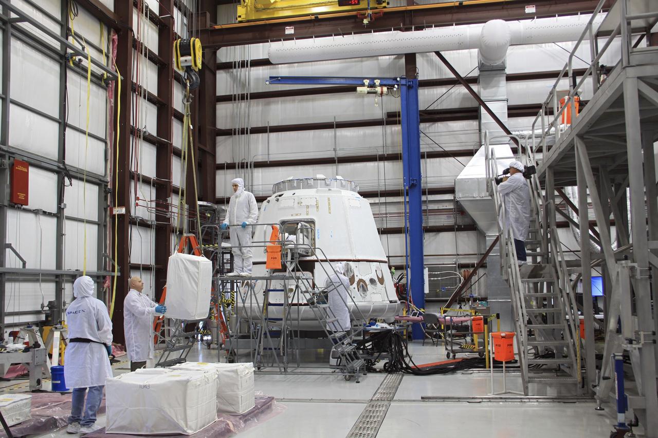 CAPE CANAVERAL, Fla. – In a processing hangar at Space Launch Complex-40 on Cape Canaveral Air Force Station in Florida, a Space Exploration Technologies technician attaches a cargo bag to the crane that will lift it toward the Dragon capsule where it will be stowed in preparation for its scheduled April 30 liftoff aboard a Falcon 9 rocket. Known as SpaceX, the launch will be the company's second demonstration test flight for NASA's Commercial Orbital Transportation Services program, or COTS. During the flight, the capsule will conduct a series of checkout procedures to test and prove its systems, including rendezvous and berthing with the International Space Station. The cargo includes food and provisions for the station’s Expedition crews, such as clothing, batteries, and computer equipment. Under COTS, NASA has partnered with two private companies to launch cargo safely to the station. For more information, visit http://www.nasa.gov/spacex. Photo credit: NASA/Jim Grossmann