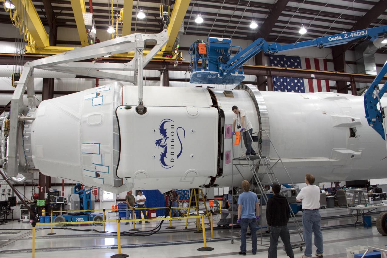 CAPE CANAVERAL, Fla. – In a processing facility at Space Launch Complex-40 on Cape Canaveral Air Force Station in Florida, Space Exploration Technologies technicians prepare to attach the Dragon capsule to the second stage of the company’s Falcon 9 rocket. Known as SpaceX, the launch will be the company's second demonstration test flight for NASA's Commercial Orbital Transportation Services program, or COTS. During the flight, the capsule will conduct a series of check-out procedures to test and prove its systems, including rendezvous and berthing with the International Space Station. If the capsule performs as planned, the NanoRacks-CubeLabs Module-9 experiments and other cargo aboard Dragon will be transferred to the station. The cargo includes food, water and provisions for the station’s Expedition crews, such as clothing, batteries and computer equipment. Under COTS, NASA has partnered with two private companies to provide resupply missions to the station. The launch is scheduled for 9:38 a.m. EDT on May 7. For more information, visit http://www.nasa.gov/spacex. Photo credit: NASA/Jim Grossmann