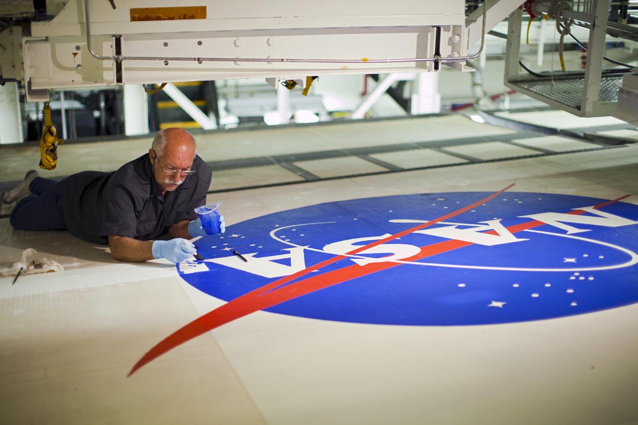 CAPE CANAVERAL, Fla. – In Orbiter Processing Facility-2 at NASA's Kennedy Space Center in Florida, Michael Williams of United Space Alliance paints the NASA logo -- known as the "meatball" -- on the left wing of space shuttle Endeavour.       Endeavour is being prepared for public display at the California Science Center in Los Angeles. Over the course of its 19-year career, Endeavour spent 299 days in space during 25 missions. For more information, visit http://www.nasa.gov/transition. Photo credit: NASA/Dimitri Gerondidakis