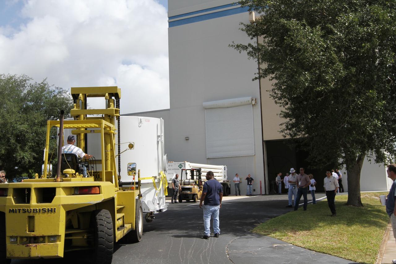 CAPE CANAVERAL, Fla. – A forklift operator moves NASA's Radiation Belt Storm Probe A, enclosed in a protective shipping container, toward the open bay door of the Astrotech payload processing facility near NASA’s Kennedy Space Center in Florida where Applied Physics Laboratory technicians will begin spacecraft testing and prelaunch preparations. The twin RBSP spacecraft arrived at Kennedy’s Shuttle Landing Facility in the cargo bay of a U.S. Air Force C-17 aircraft earlier in the day.            The RBSP mission will help us understand the sun’s influence on Earth and near-Earth space by studying the Earth’s radiation belts on various scales of space and time. The RBSP instruments will provide the measurements needed to characterize and quantify the plasma processes that produce very energetic ions and relativistic electrons. The mission is part of NASA’s broader Living With a Star Program that was conceived to explore fundamental processes that operate throughout the solar system, and in particular those that generate hazardous space weather effects in the vicinity of Earth and phenomena that could impact solar system exploration. RBSP is scheduled to begin its mission of exploration of Earth's Van Allen Radiation Belts and the extremes of space weather after launch. Launch aboard a United Launch Alliance Atlas V rocket is scheduled for August 23.  For more information, visit http://www.nasa.gov/rbsp.  Photo credit: NASA/Kim Shiflett