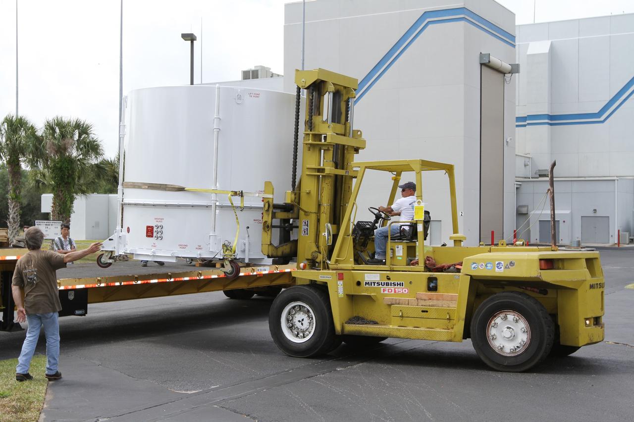 CAPE CANAVERAL, Fla. – A forklift operator offloads NASA's Radiation Belt Storm Probe B, enclosed in a protective shipping container, from a flatbed truck at the Astrotech payload processing facility near NASA’s Kennedy Space Center in Florida where Applied Physics Laboratory technicians will begin spacecraft testing and prelaunch preparations.  The twin RBSP spacecraft arrived at Kennedy’s Shuttle Landing Facility in the cargo bay of a U.S. Air Force C-17 aircraft earlier in the day.          The RBSP mission will help us understand the sun’s influence on Earth and near-Earth space by studying the Earth’s radiation belts on various scales of space and time. The RBSP instruments will provide the measurements needed to characterize and quantify the plasma processes that produce very energetic ions and relativistic electrons. The mission is part of NASA’s broader Living With a Star Program that was conceived to explore fundamental processes that operate throughout the solar system, and in particular those that generate hazardous space weather effects in the vicinity of Earth and phenomena that could impact solar system exploration. RBSP is scheduled to begin its mission of exploration of Earth's Van Allen Radiation Belts and the extremes of space weather after launch. Launch aboard a United Launch Alliance Atlas V rocket is scheduled for August 23.  For more information, visit http://www.nasa.gov/rbsp.  Photo credit: NASA/Kim Shiflett