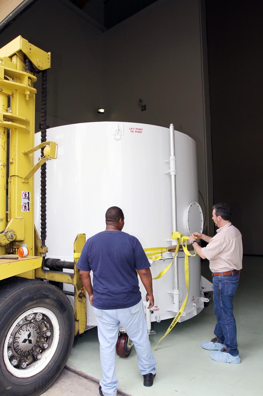 CAPE CANAVERAL, Fla. – A worker releases NASA's Radiation Belt Storm Probe B, enclosed in a protective shipping container, from the forklift that delivered it to the airlock of the Astrotech payload processing facility near NASA’s Kennedy Space Center in Florida where Applied Physics Laboratory technicians will begin spacecraft testing and prelaunch preparations.  The twin RBSP spacecraft arrived at Kennedy’s Shuttle Landing Facility in the cargo bay of a U.S. Air Force C-17 aircraft earlier in the day.          The RBSP mission will help us understand the sun’s influence on Earth and near-Earth space by studying the Earth’s radiation belts on various scales of space and time. The RBSP instruments will provide the measurements needed to characterize and quantify the plasma processes that produce very energetic ions and relativistic electrons. The mission is part of NASA’s broader Living With a Star Program that was conceived to explore fundamental processes that operate throughout the solar system, and in particular those that generate hazardous space weather effects in the vicinity of Earth and phenomena that could impact solar system exploration. RBSP is scheduled to begin its mission of exploration of Earth's Van Allen Radiation Belts and the extremes of space weather after launch. Launch aboard a United Launch Alliance Atlas V rocket is scheduled for August 23.  For more information, visit http://www.nasa.gov/rbsp.  Photo credit: NASA/Kim Shiflett
