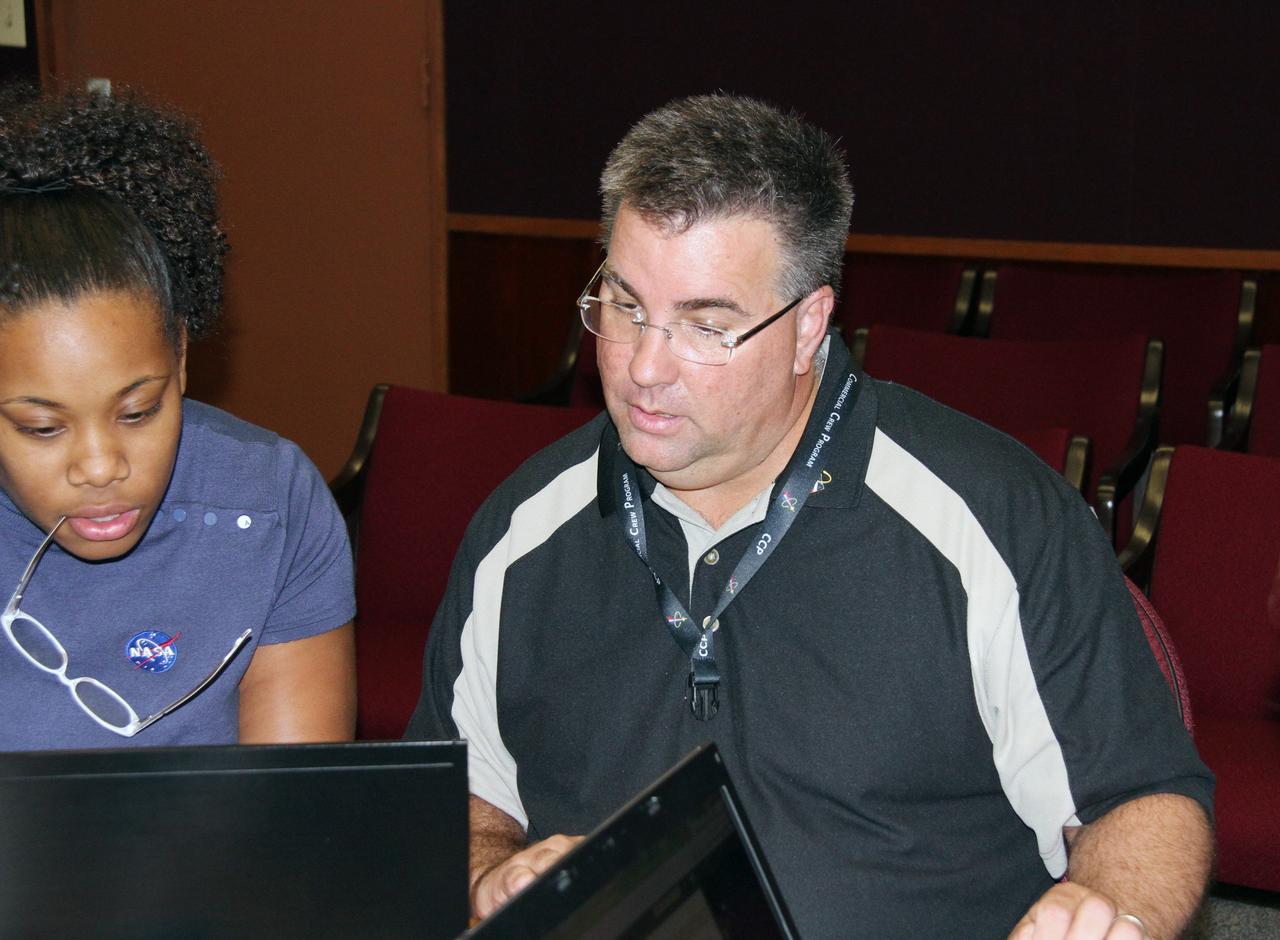 CAPE CANAVERAL, Fla. – The manager of NASA's Commercial Crew Program CCP, Ed Mango, hosts a virtual conversation, called a Tweet Chat, with Twitter followers from around the world. Those who follow www.twitter.com/commercial_crew had an hour-long opportunity to ask Mango questions about NASA’s efforts to get astronauts to low Earth orbit and the International Space Station aboard American rockets and spacecraft. Mango stuck to the social networking service's 140 character limit and answered dozens of questions. At left, is Brittani Sims, a member of the CCP team.            The goal of CCP is to drive down the cost of space travel as well as open up space to more people than ever before by balancing industry’s own innovative capabilities with NASA's 50 years of human spaceflight experience. Seven aerospace companies are maturing launch vehicle and spacecraft designs under the program’s second round of development, called Commercial Crew Development Round 2 CCDev2), including Alliant Techsystems Inc. ATK, The Boeing Co., Excalibur Almaz Inc., Blue Origin, Sierra Nevada, Space Exploration Technologies SpaceX, and United Launch Alliance ULA. For more information, visit www.nasa.gov/commercialcrew. Image credit: NASA/Gianni Woods