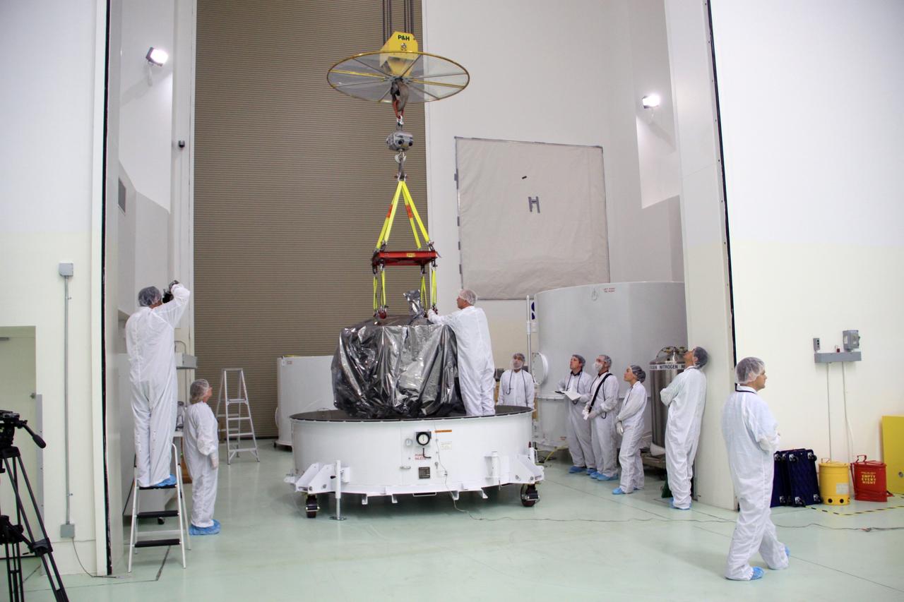 CAPE CANAVERAL, Fla. – In the clean room high bay at the Astrotech payload processing facility near NASA’s Kennedy Space Center in Florida, Applied Physics Laboratory technicians prepare to lift NASA's Radiation Belt Storm Probe A, wrapped in a protective shroud, from the bottom of its shipping container. Prelaunch preparations and spacecraft testing will follow.      The Radiation Belt Storm Probes, or RBSP, mission will help us understand the sun’s influence on Earth and near-Earth space by studying the Earth’s radiation belts on various scales of space and time. RBSP instruments will provide the measurements needed to characterize and quantify the plasma processes that produce very energetic ions and relativistic electrons. The mission is part of NASA’s broader Living With a Star Program that was conceived to explore fundamental processes that operate throughout the solar system, particularly those that generate hazardous space weather effects in the vicinity of Earth and phenomena that could impact solar system exploration. RBSP will begin its mission of exploration of Earth's Van Allen radiation belts and the extremes of space weather after launch. Launch aboard a United Launch Alliance Atlas V rocket is scheduled for August 23. For more information, visit http://www.nasa.gov/rbsp. Photo credit: NASA/Jim Grossmann