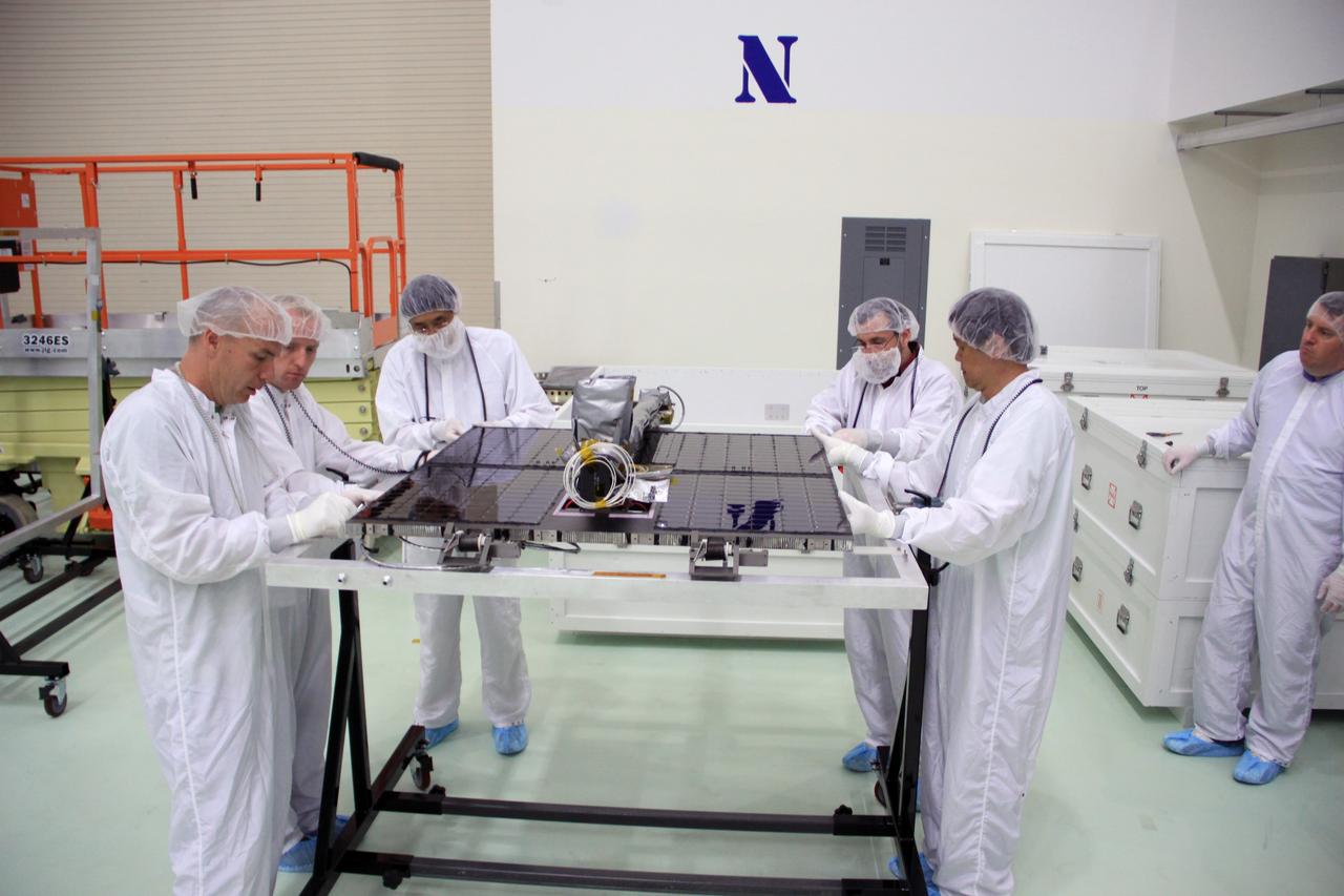 CAPE CANAVERAL, Fla. – In the clean room high bay at the Astrotech payload processing facility near NASA’s Kennedy Space Center in Florida, Applied Physics Laboratory technicians place the one of the solar arrays for NASA's Radiation Belt Storm Probe A into a holding fixture.      The Radiation Belt Storm Probes, or RBSP, mission will help us understand the sun’s influence on Earth and near-Earth space by studying the Earth’s radiation belts on various scales of space and time. RBSP instruments will provide the measurements needed to characterize and quantify the plasma processes that produce very energetic ions and relativistic electrons. The mission is part of NASA’s broader Living With a Star Program that was conceived to explore fundamental processes that operate throughout the solar system, particularly those that generate hazardous space weather effects in the vicinity of Earth and phenomena that could impact solar system exploration. RBSP will begin its mission of exploration of Earth's Van Allen radiation belts and the extremes of space weather after launch. Launch aboard a United Launch Alliance Atlas V rocket is scheduled for August 23. For more information, visit http://www.nasa.gov/rbsp. Photo credit: NASA/Jim Grossmann