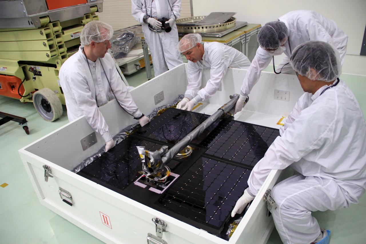 CAPE CANAVERAL, Fla. – In the clean room high bay at the Astrotech payload processing facility near NASA’s Kennedy Space Center in Florida, a team approach is used by Applied Physics Laboratory technicians to lift one of the solar arrays for NASA's Radiation Belt Storm Probe A from its shipping container.      The Radiation Belt Storm Probes, or RBSP, mission will help us understand the sun’s influence on Earth and near-Earth space by studying the Earth’s radiation belts on various scales of space and time. RBSP instruments will provide the measurements needed to characterize and quantify the plasma processes that produce very energetic ions and relativistic electrons. The mission is part of NASA’s broader Living With a Star Program that was conceived to explore fundamental processes that operate throughout the solar system, particularly those that generate hazardous space weather effects in the vicinity of Earth and phenomena that could impact solar system exploration. RBSP will begin its mission of exploration of Earth's Van Allen radiation belts and the extremes of space weather after launch. Launch aboard a United Launch Alliance Atlas V rocket is scheduled for August 23. For more information, visit http://www.nasa.gov/rbsp. Photo credit: NASA/Jim Grossmann