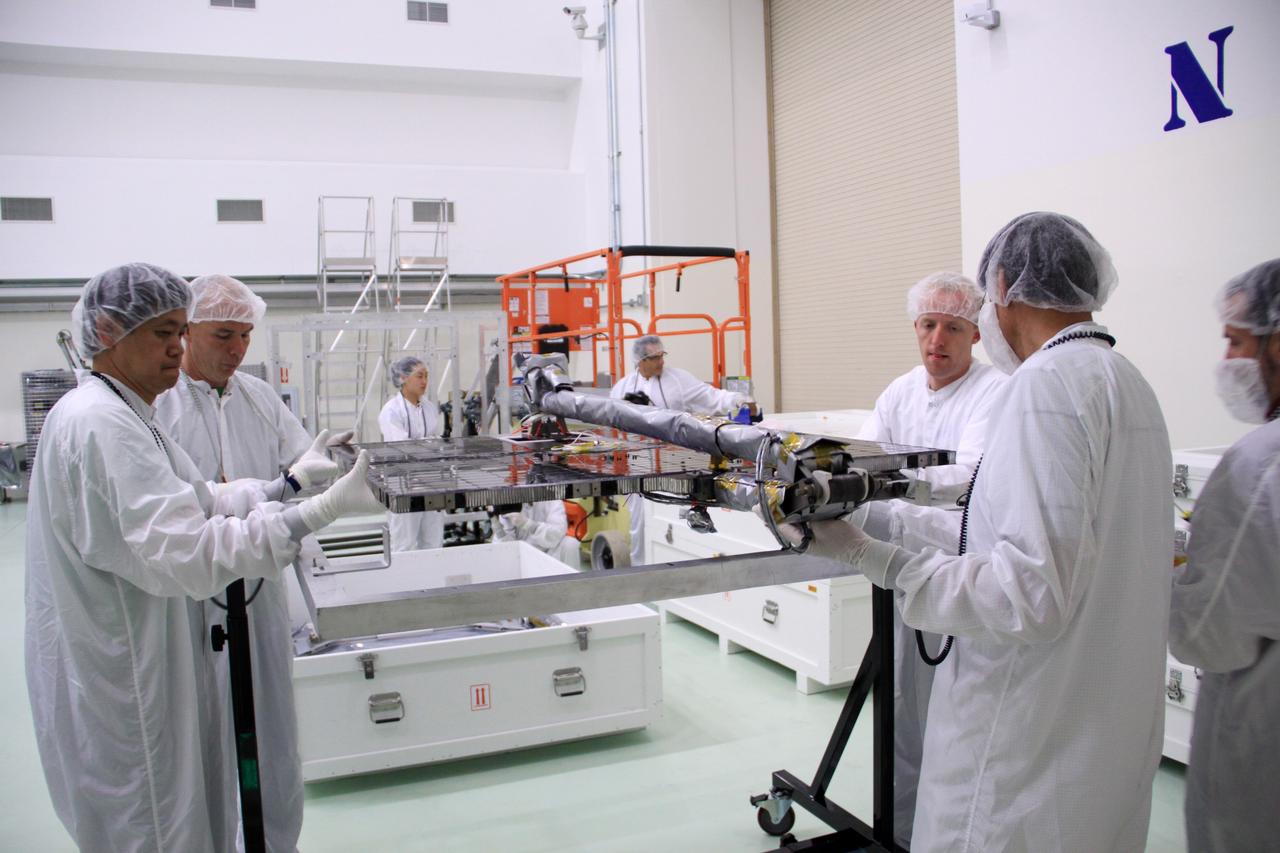CAPE CANAVERAL, Fla. – In the clean room high bay at the Astrotech payload processing facility near NASA’s Kennedy Space Center in Florida, Applied Physics Laboratory technicians steady one of the solar arrays for NASA's Radiation Belt Storm Probe A as it is secured into a holding fixture.      The Radiation Belt Storm Probes, or RBSP, mission will help us understand the sun’s influence on Earth and near-Earth space by studying the Earth’s radiation belts on various scales of space and time. RBSP instruments will provide the measurements needed to characterize and quantify the plasma processes that produce very energetic ions and relativistic electrons. The mission is part of NASA’s broader Living With a Star Program that was conceived to explore fundamental processes that operate throughout the solar system, particularly those that generate hazardous space weather effects in the vicinity of Earth and phenomena that could impact solar system exploration. RBSP will begin its mission of exploration of Earth's Van Allen radiation belts and the extremes of space weather after launch. Launch aboard a United Launch Alliance Atlas V rocket is scheduled for August 23. For more information, visit http://www.nasa.gov/rbsp. Photo credit: NASA/Jim Grossmann