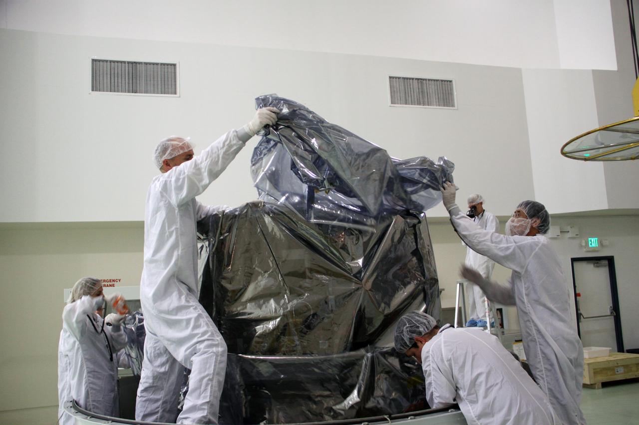 CAPE CANAVERAL, Fla. – In the clean room high bay at the Astrotech payload processing facility near NASA’s Kennedy Space Center in Florida, Applied Physics Laboratory technicians prepare NASA's Radiation Belt Storm Probe B, wrapped in a protective shroud, to be lifted from the bottom of its shipping container. Prelaunch preparations and spacecraft testing will follow.      The Radiation Belt Storm Probes, or RBSP, mission will help us understand the sun’s influence on Earth and near-Earth space by studying the Earth’s radiation belts on various scales of space and time. RBSP instruments will provide the measurements needed to characterize and quantify the plasma processes that produce very energetic ions and relativistic electrons. The mission is part of NASA’s broader Living With a Star Program that was conceived to explore fundamental processes that operate throughout the solar system, particularly those that generate hazardous space weather effects in the vicinity of Earth and phenomena that could impact solar system exploration. RBSP will begin its mission of exploration of Earth's Van Allen radiation belts and the extremes of space weather after launch. Launch aboard a United Launch Alliance Atlas V rocket is scheduled for August 23. For more information, visit http://www.nasa.gov/rbsp. Photo credit: NASA/Jim Grossmann
